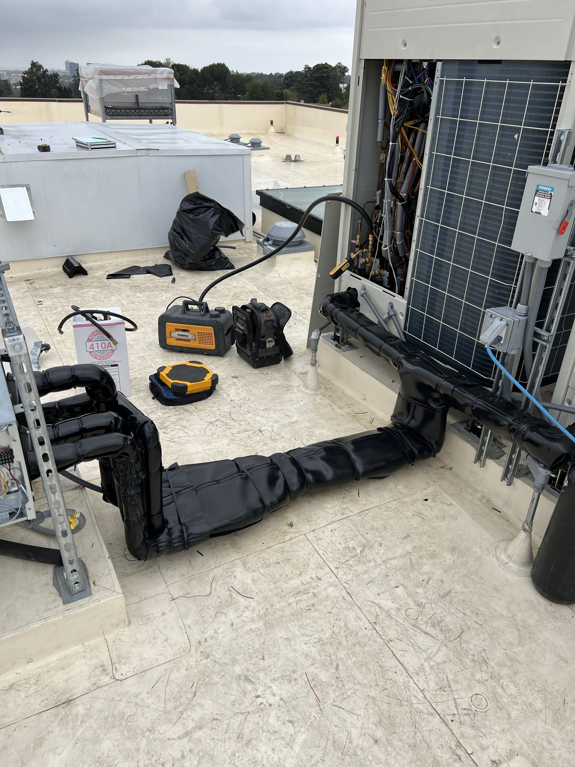 Welder in a workshop, working on metal ductwork, sparks flying.