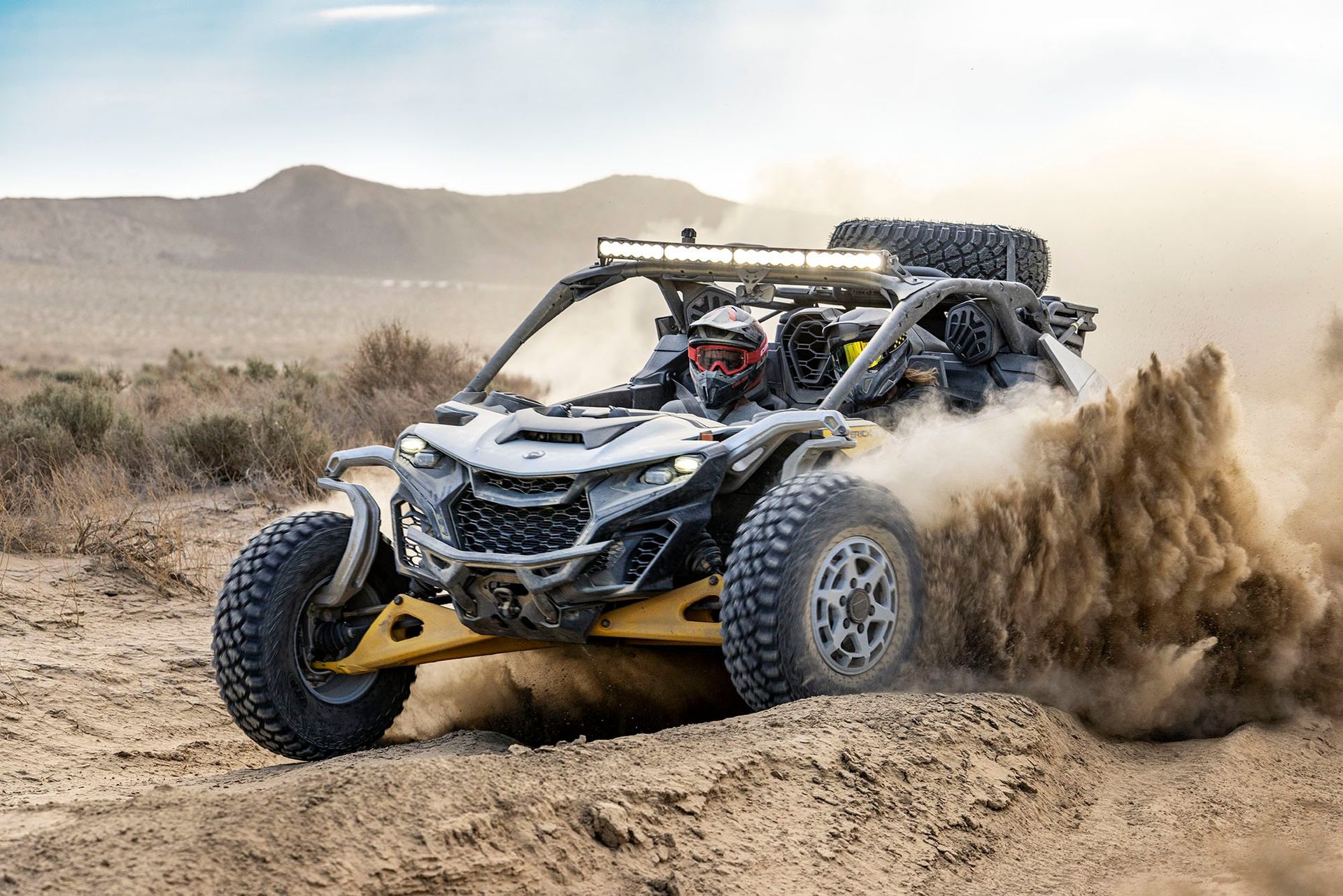 a person is riding a can-am utv on a dirt road