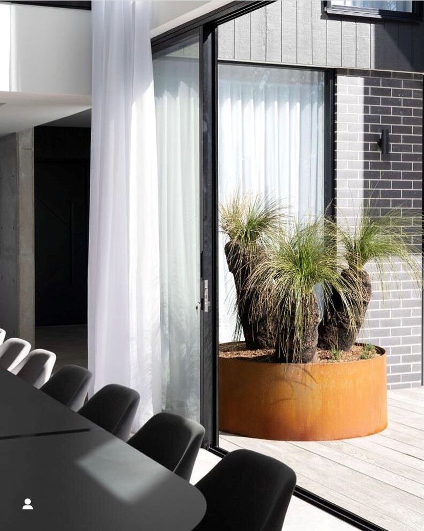 A room with a table and chairs and a potted plant