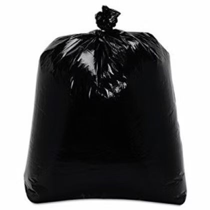 A black garbage bag is sitting on a white surface.