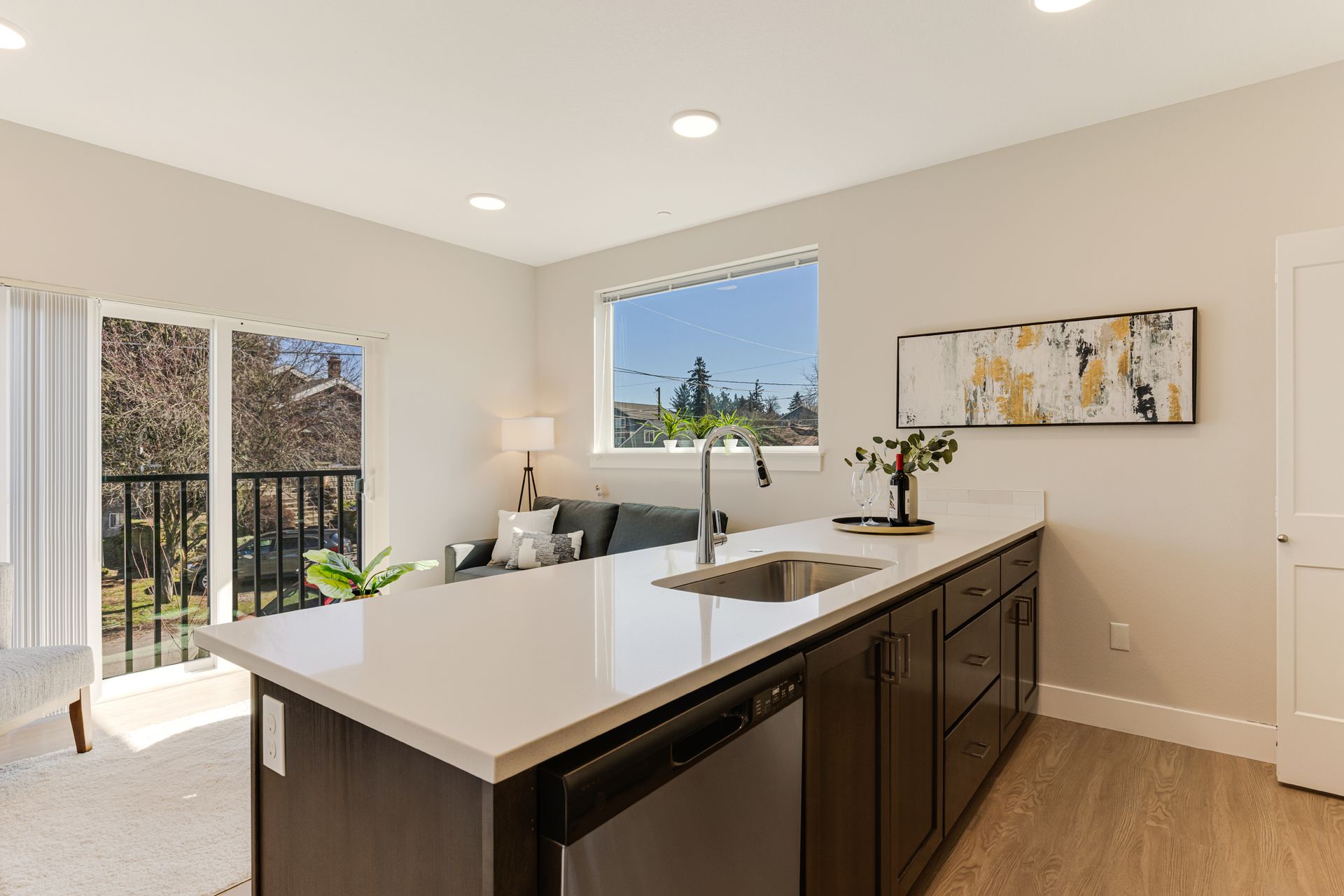 A kitchen with a large island , sink , dishwasher and stainless steel appliances.