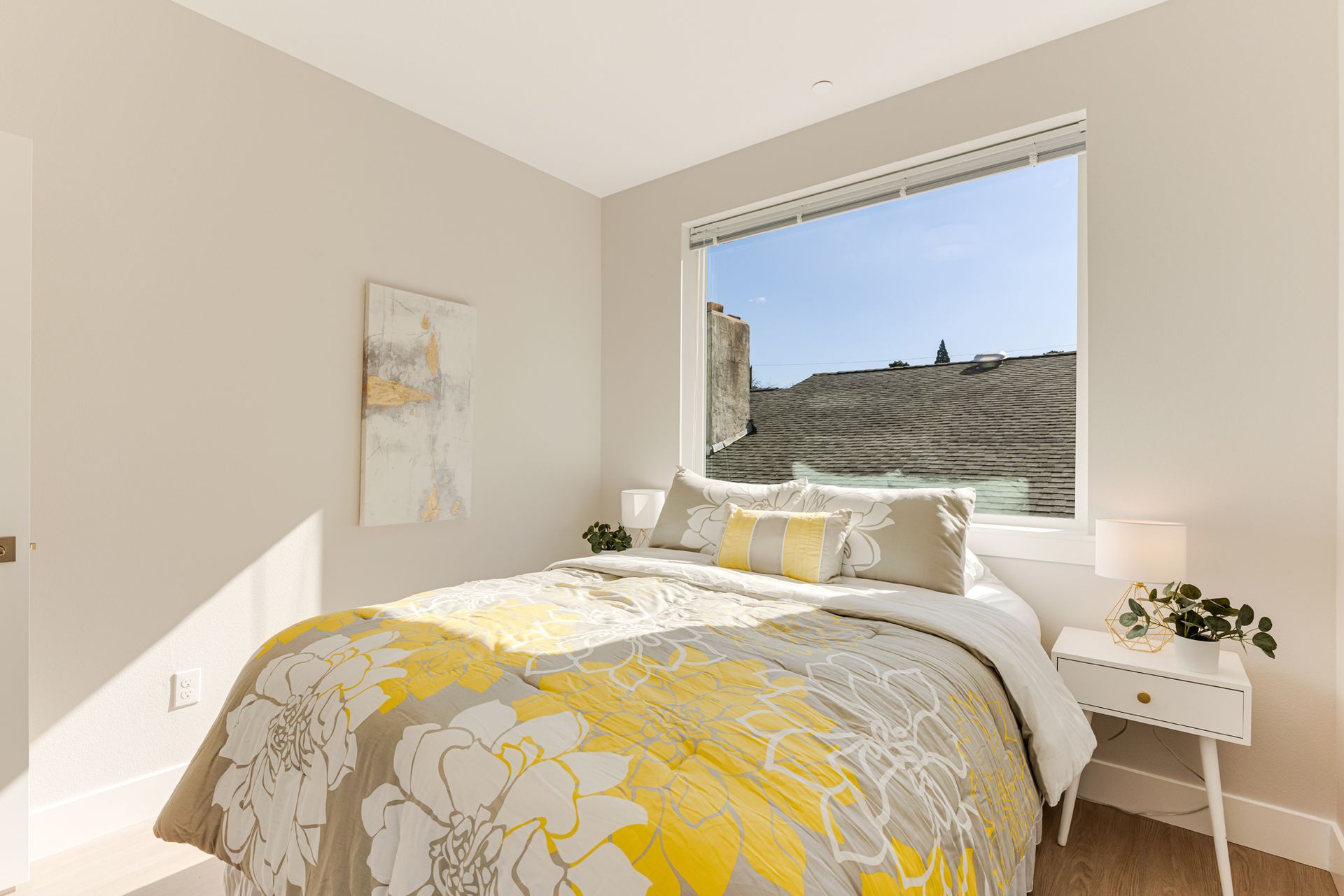 A bedroom with a bed and a window with a view of a city.