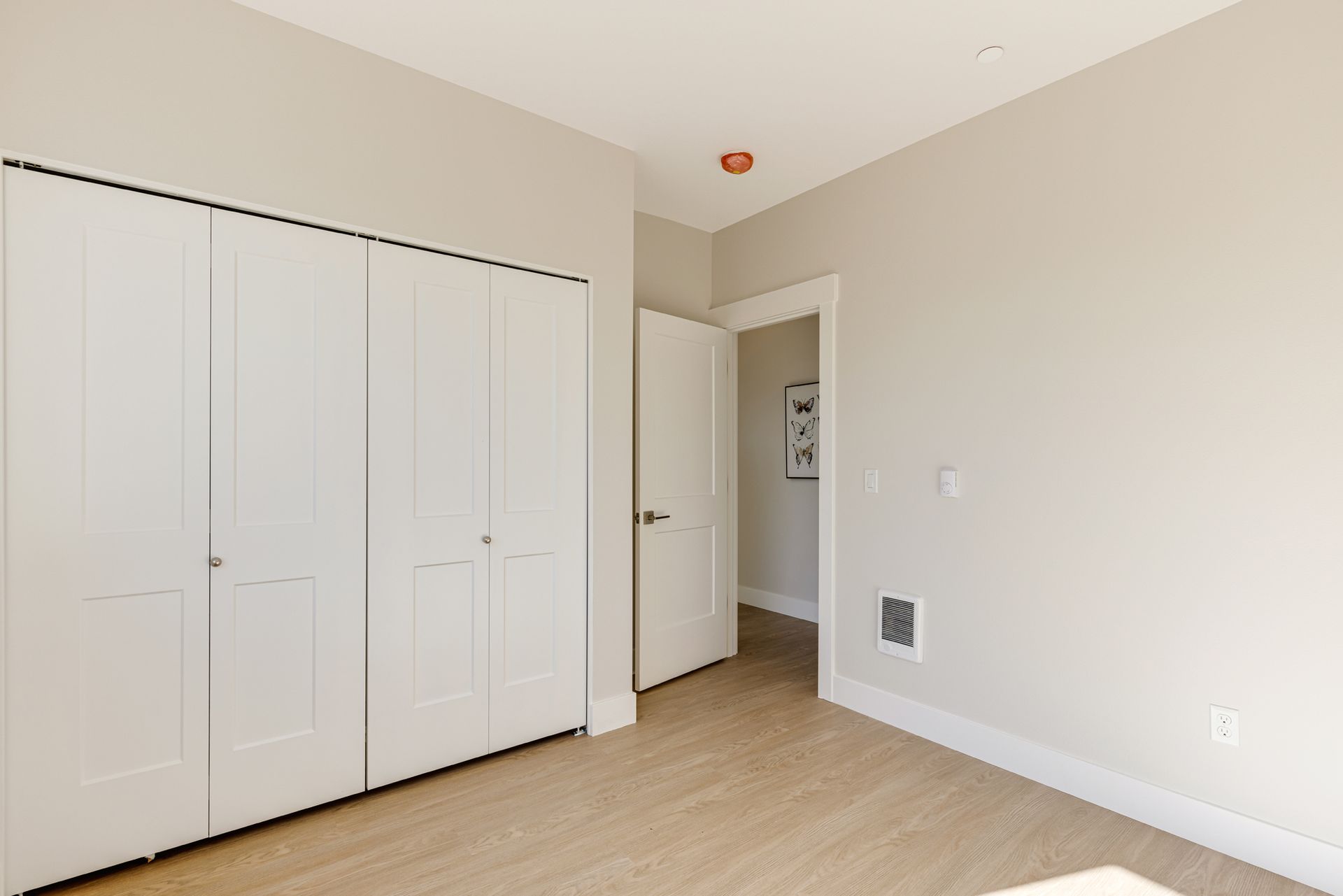 A bedroom with a lot of closets and a door.