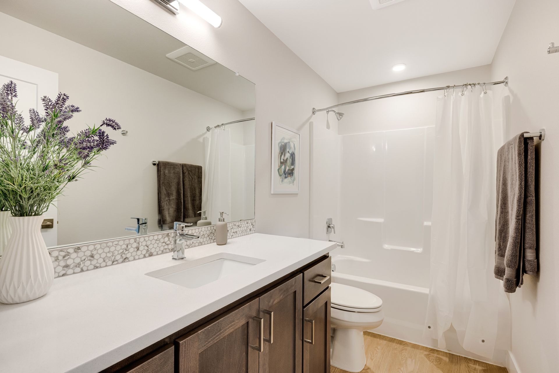 A bathroom with a sink , toilet , bathtub and mirror.