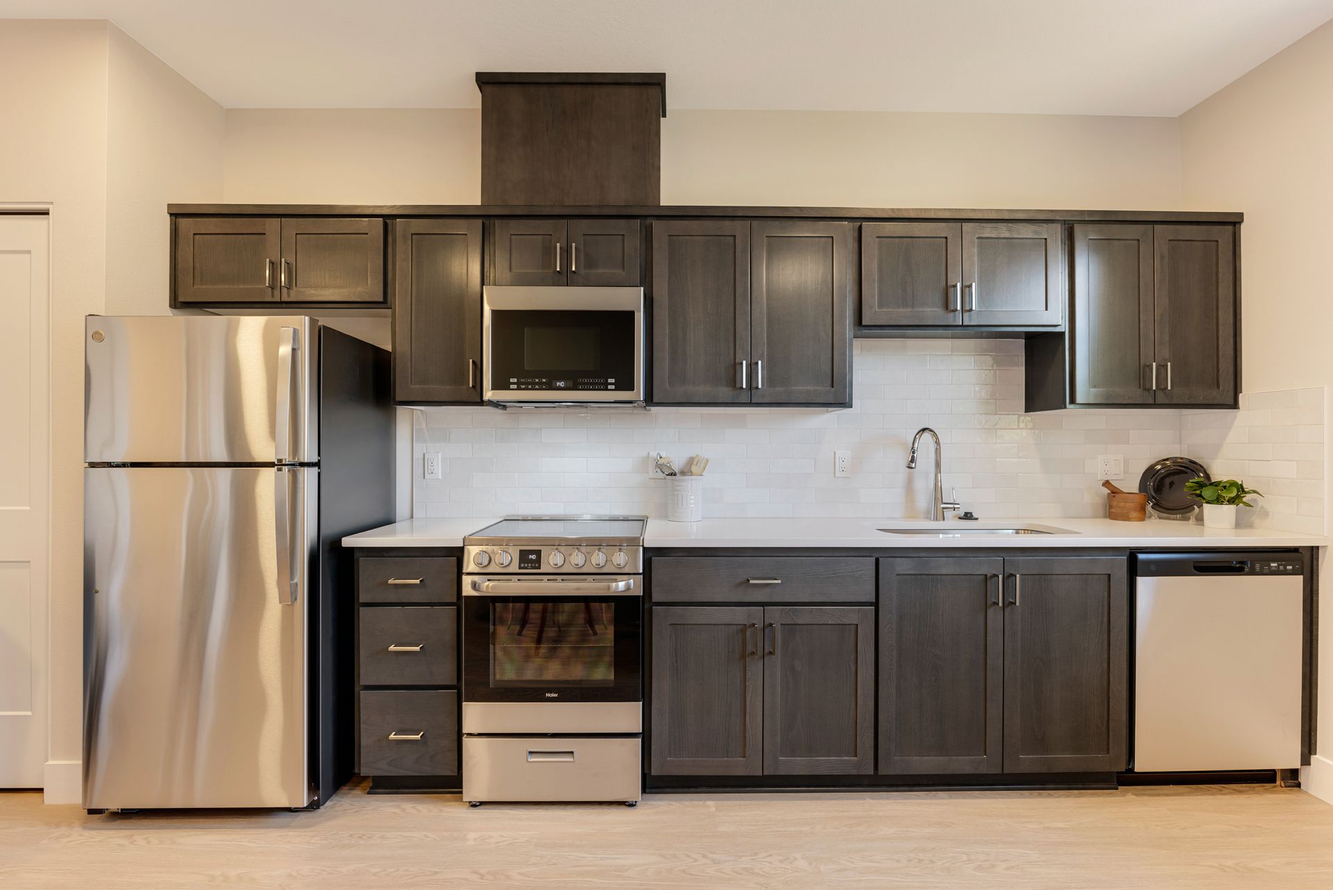 A kitchen with stainless steel appliances and gray cabinets