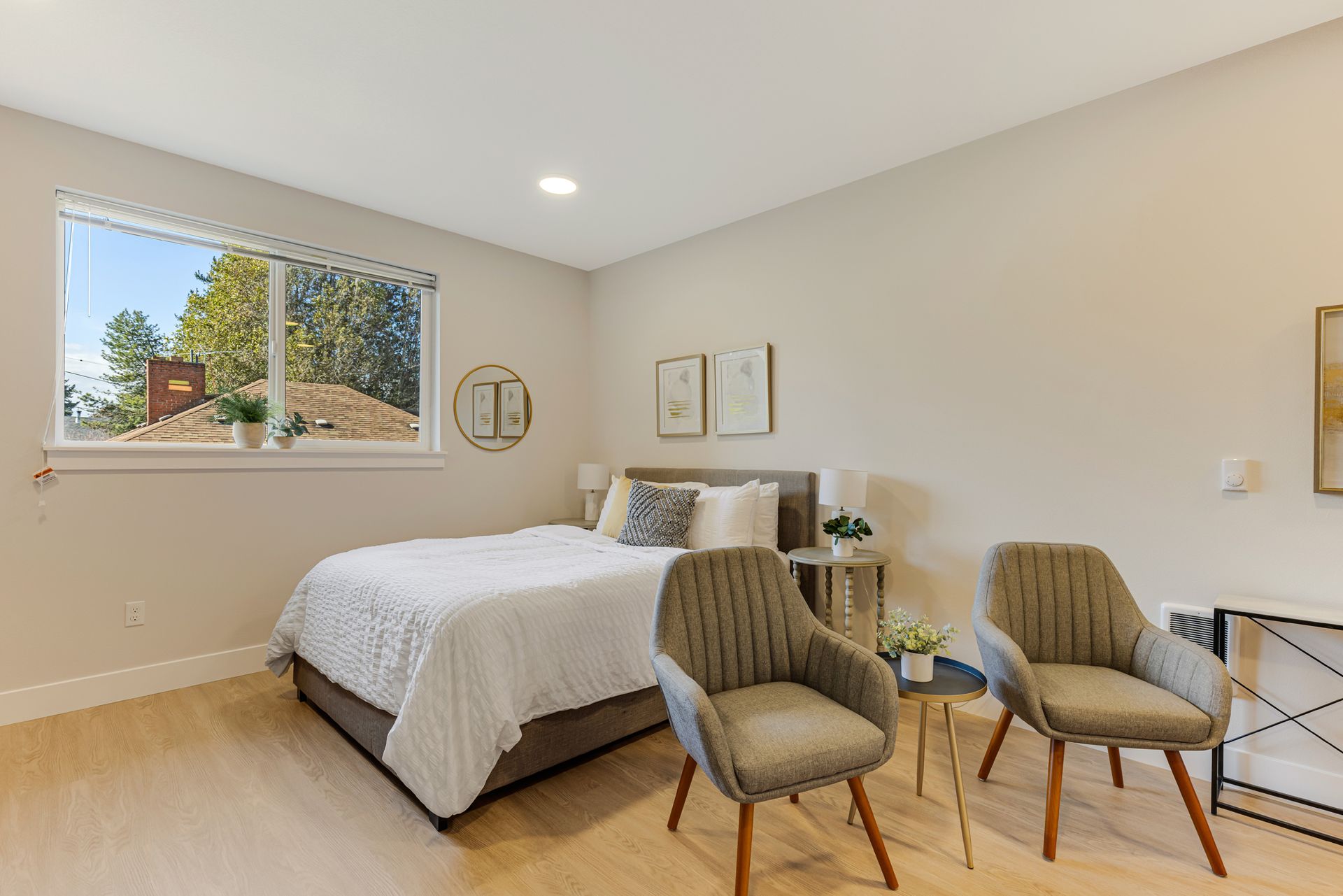 A bedroom with a bed , two chairs and a window.