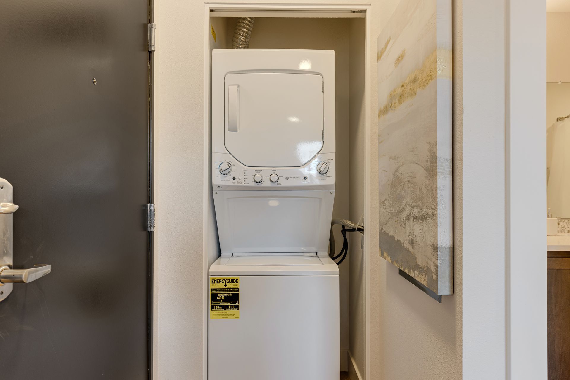 A washer and dryer are stacked on top of each other in a closet.