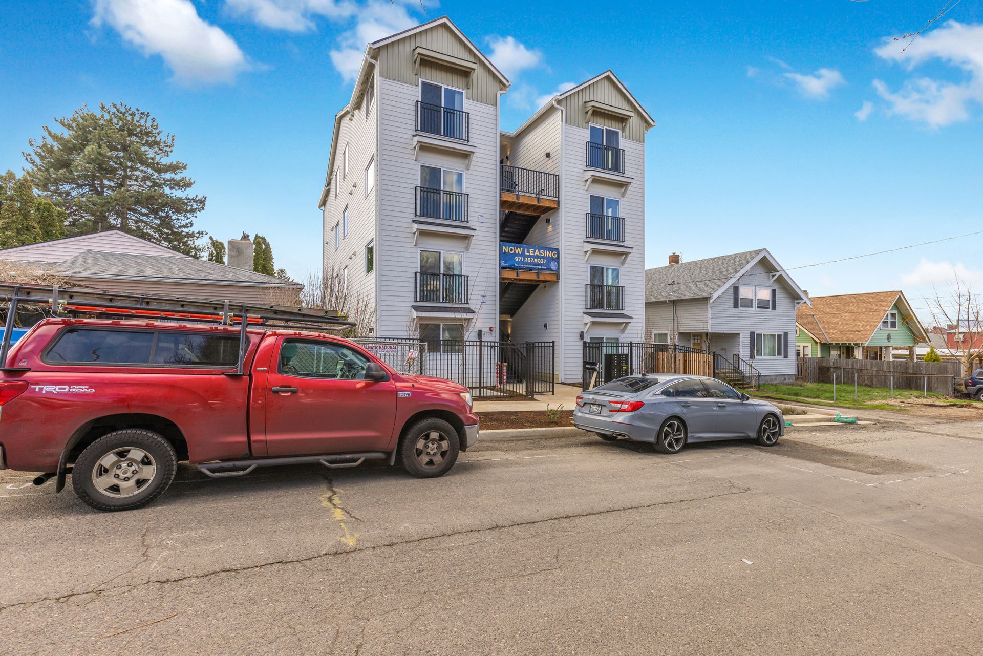 A red truck is parked in front of a building.