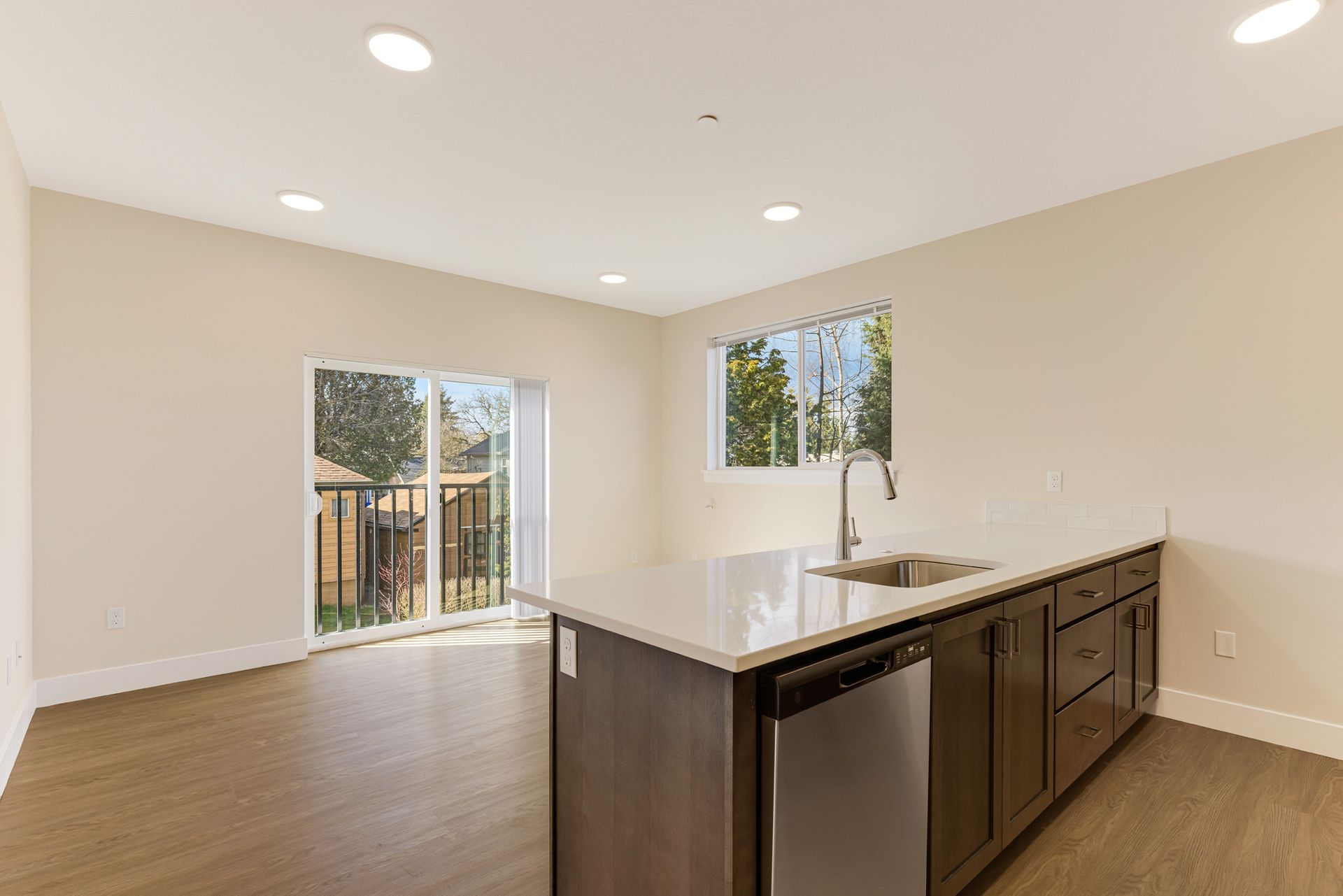 An empty kitchen with stainless steel appliances and a large island.