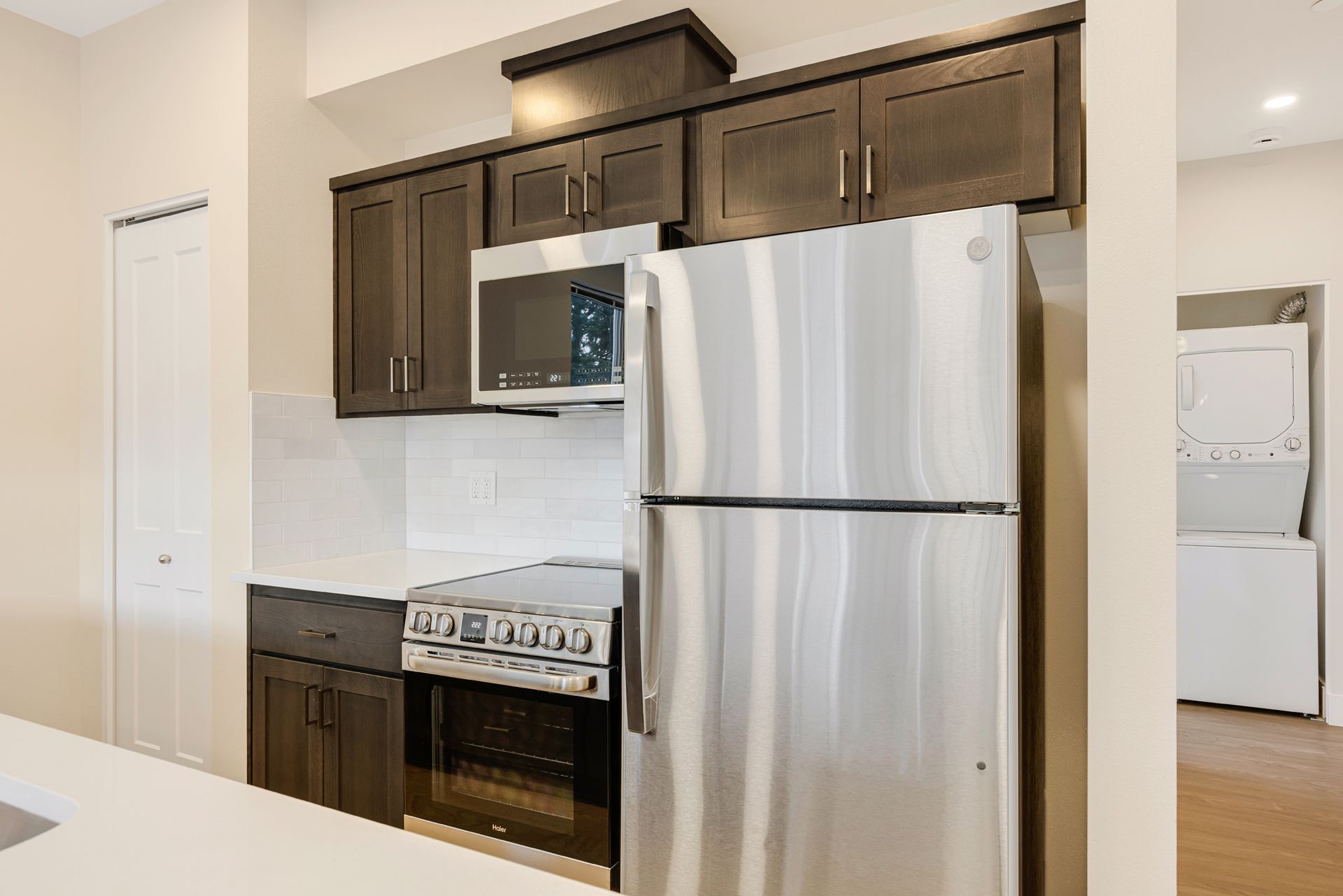 A kitchen with a stainless steel refrigerator , stove , and microwave.