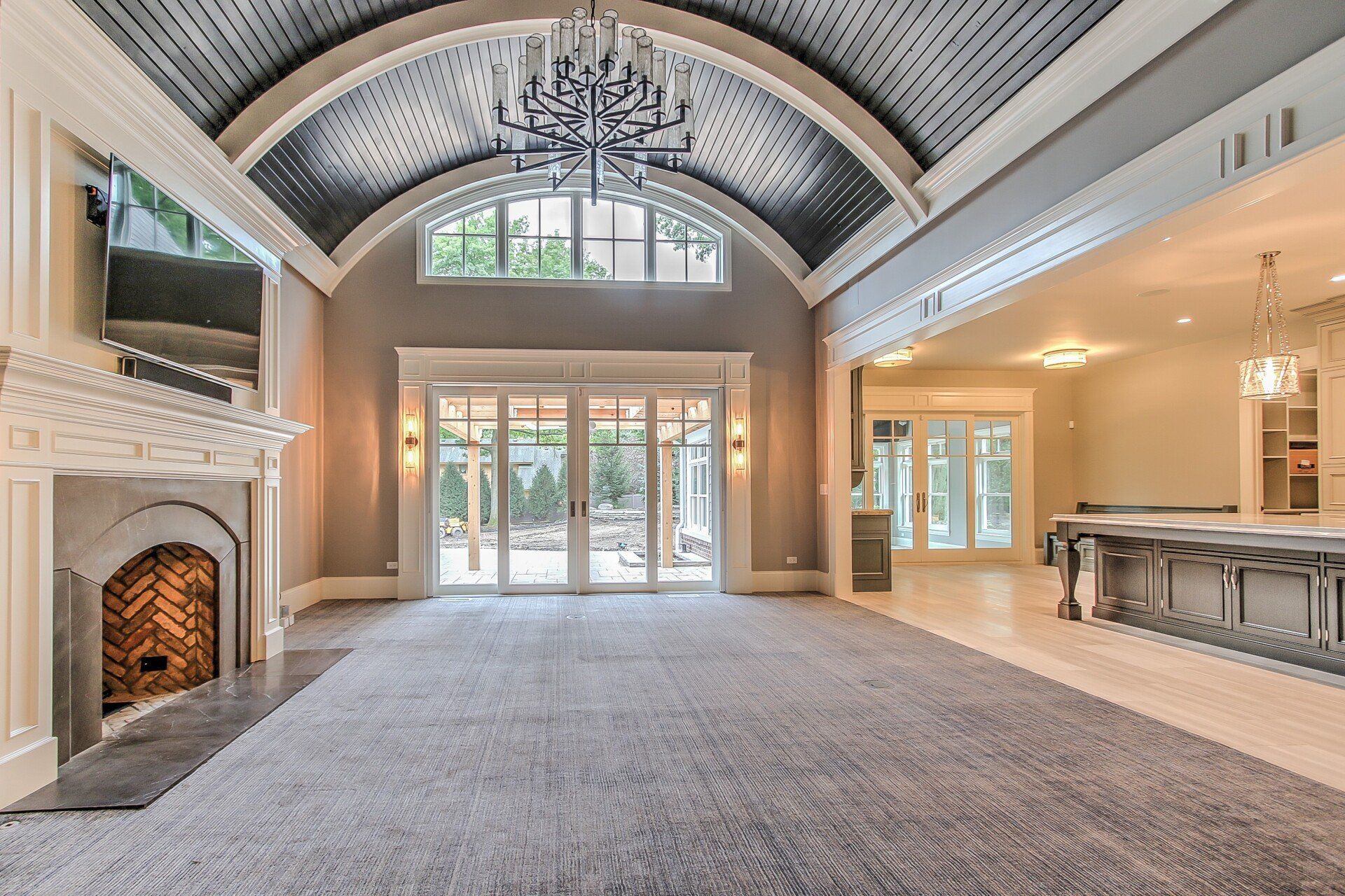A large empty room with a fireplace and a chandelier