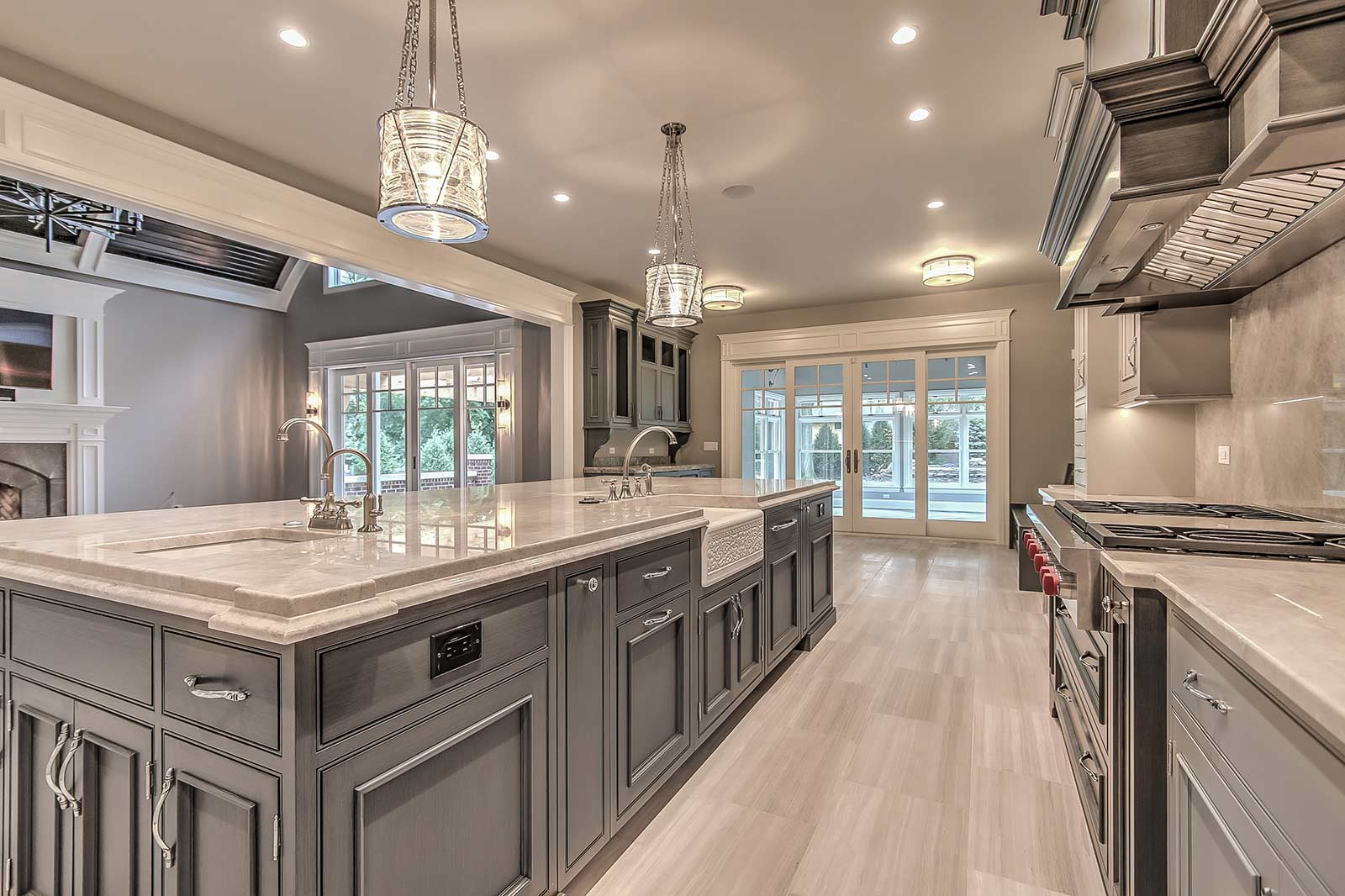 A large kitchen with gray cabinets and white counter tops.