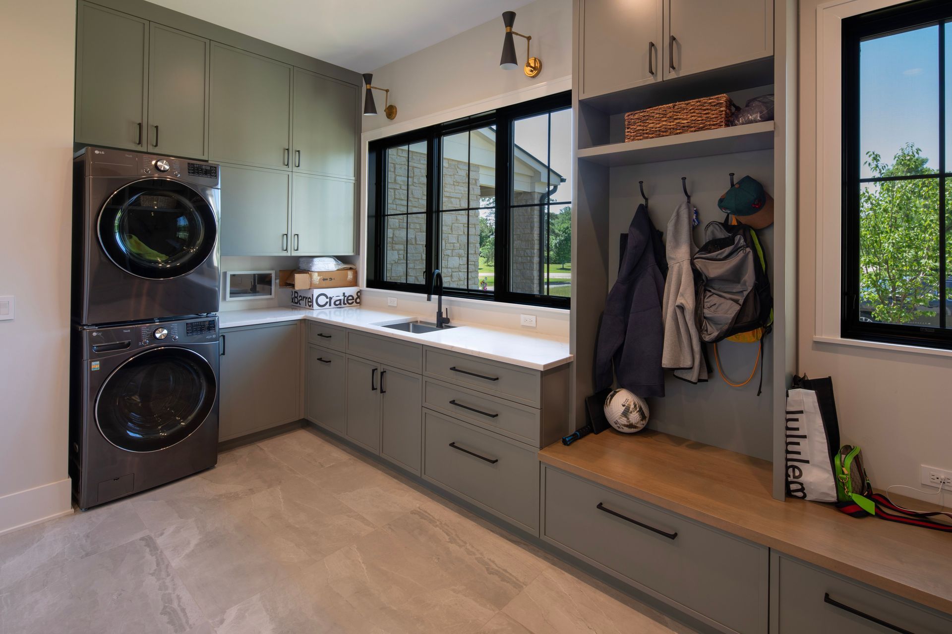 A laundry room with a washer and dryer and a bench.