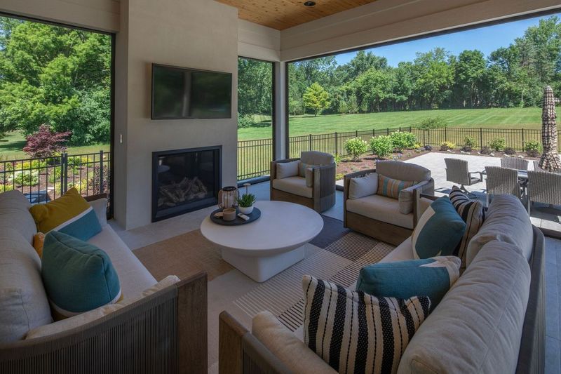 A living room with a fireplace , couch , chairs and a television.