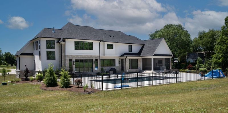 A large white house with a pool in the backyard