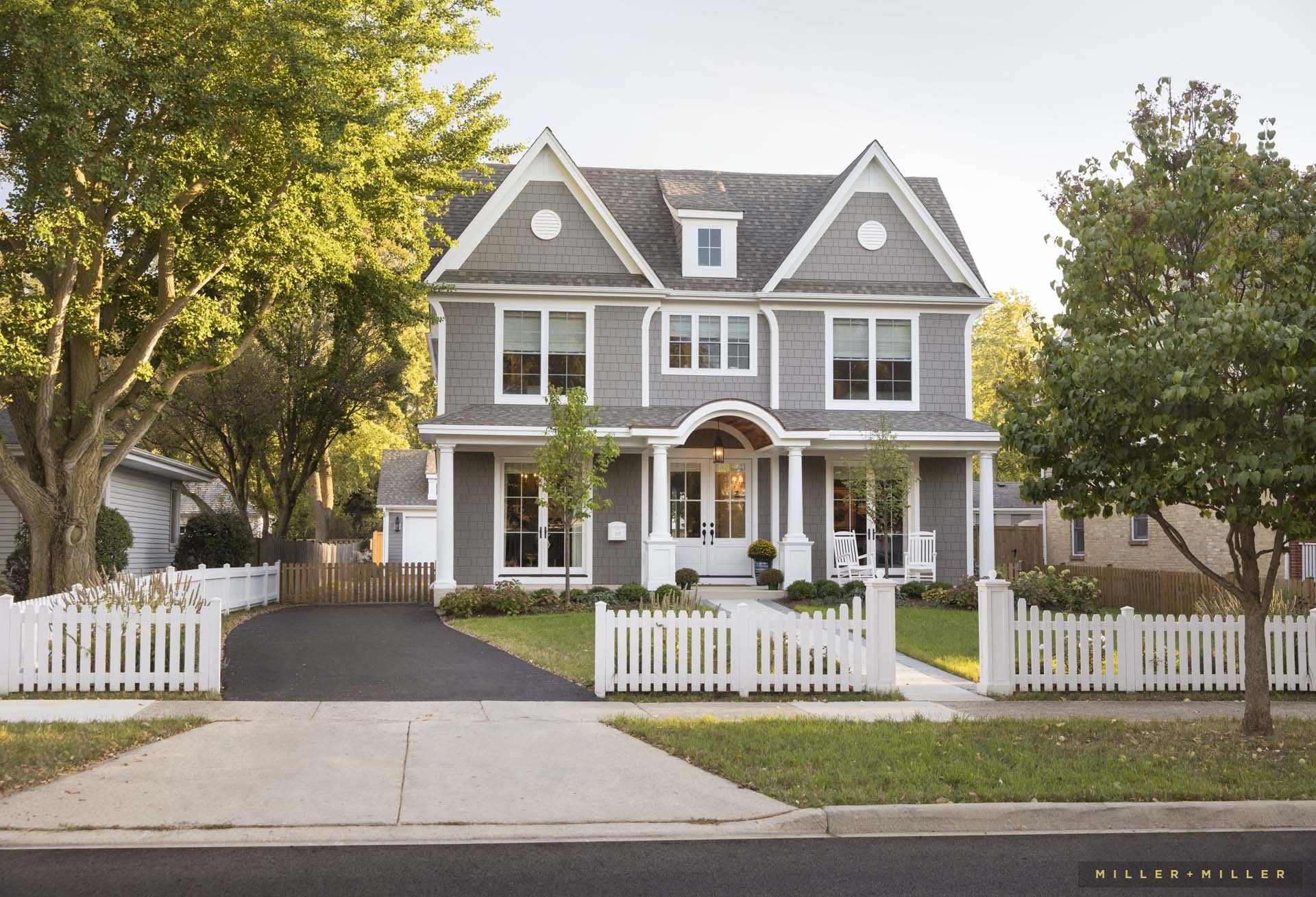 A large house with a white picket fence in front of it