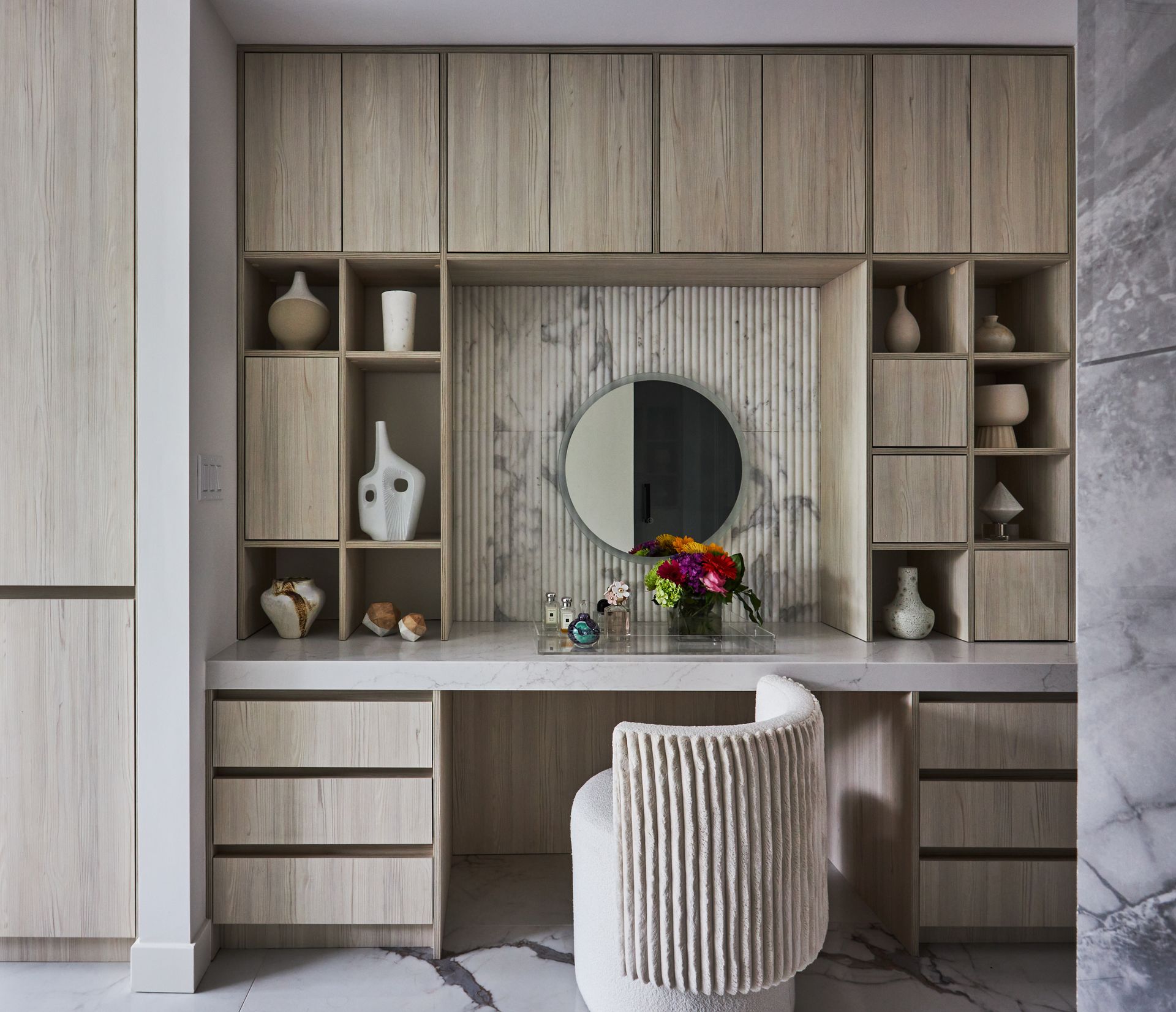 There is a vanity with a chair and a mirror in the room.