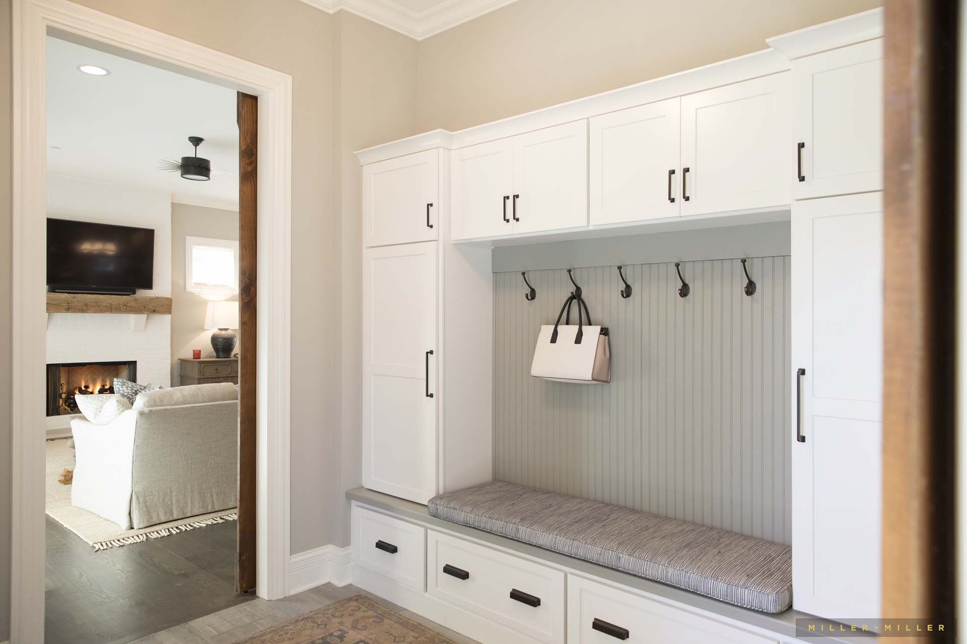 There is a bench in the middle of the room with a purse hanging from it.