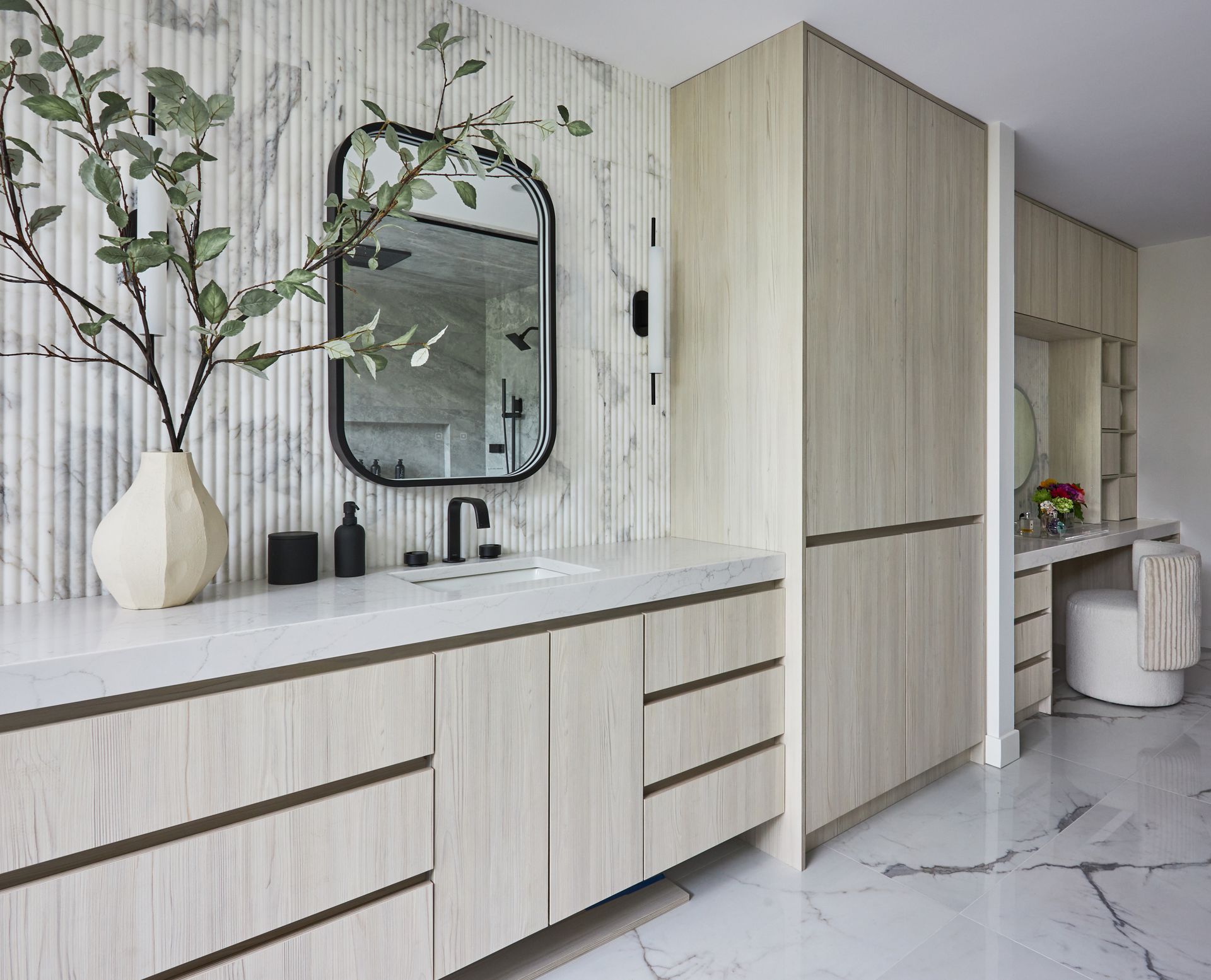 A bathroom with a sink , mirror and cabinets.