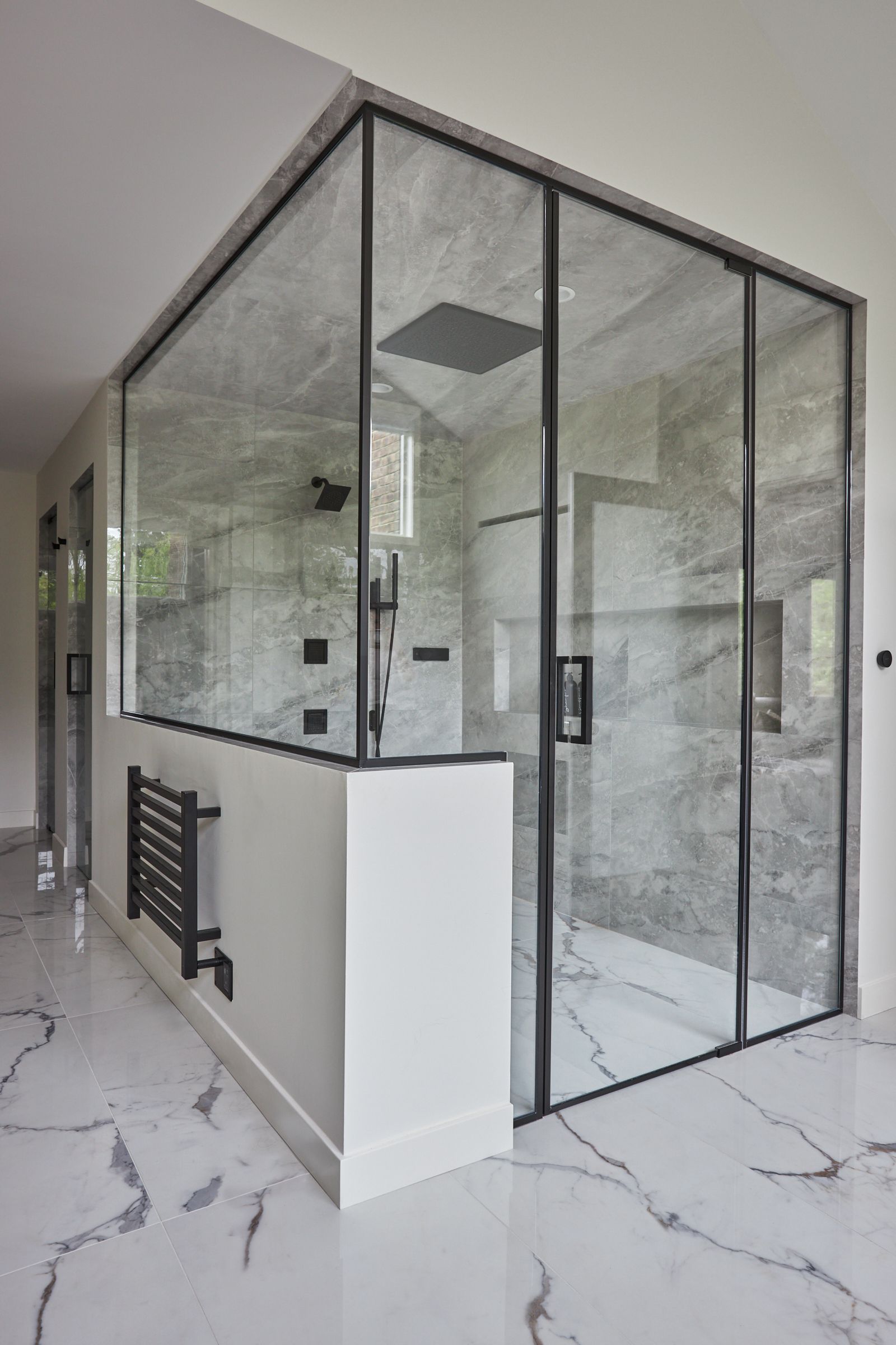 A bathroom with sliding glass doors and marble floors.