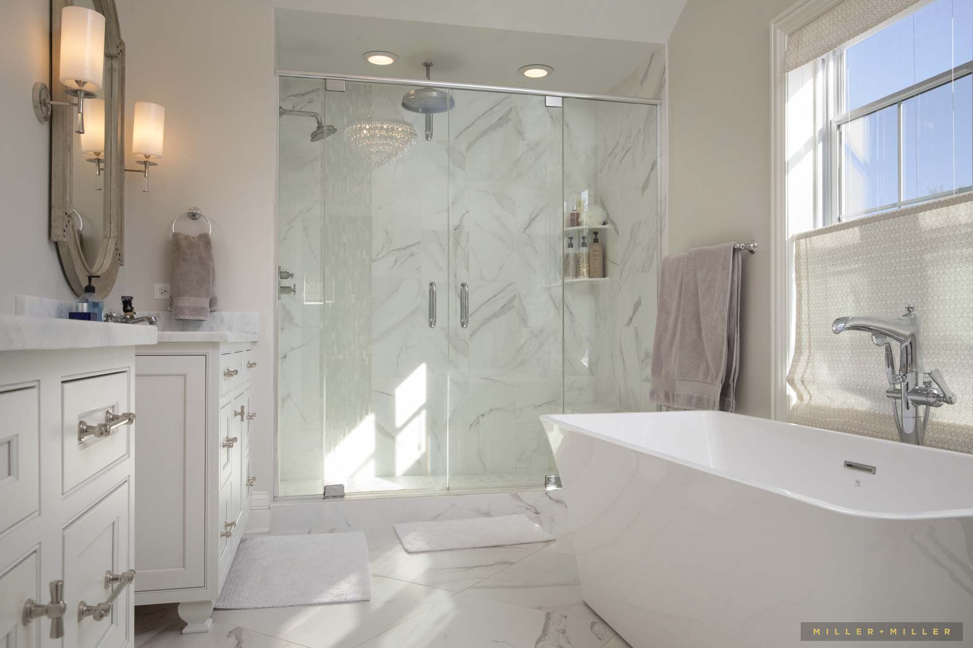 A bathroom with a tub , sink , shower and window.