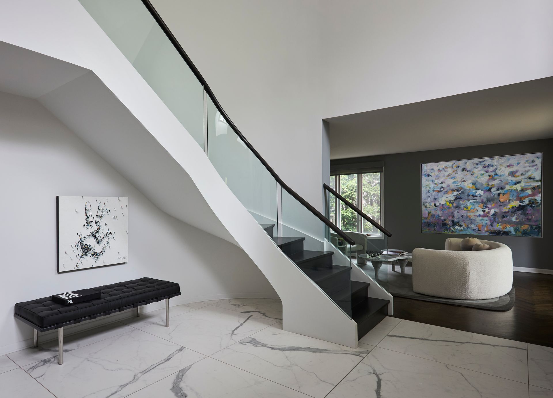 A staircase with a glass railing in a living room