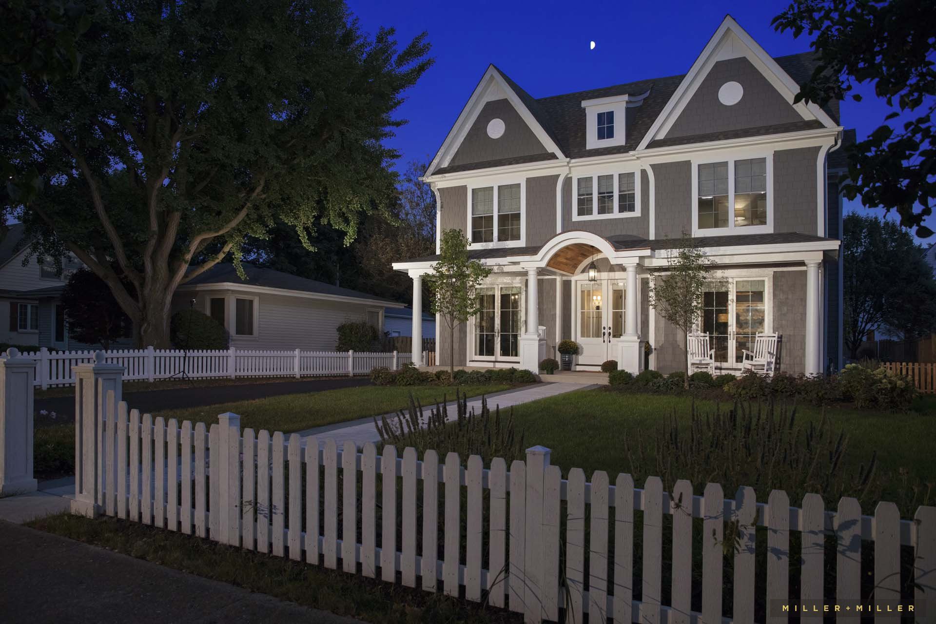 A large house with a white picket fence in front of it