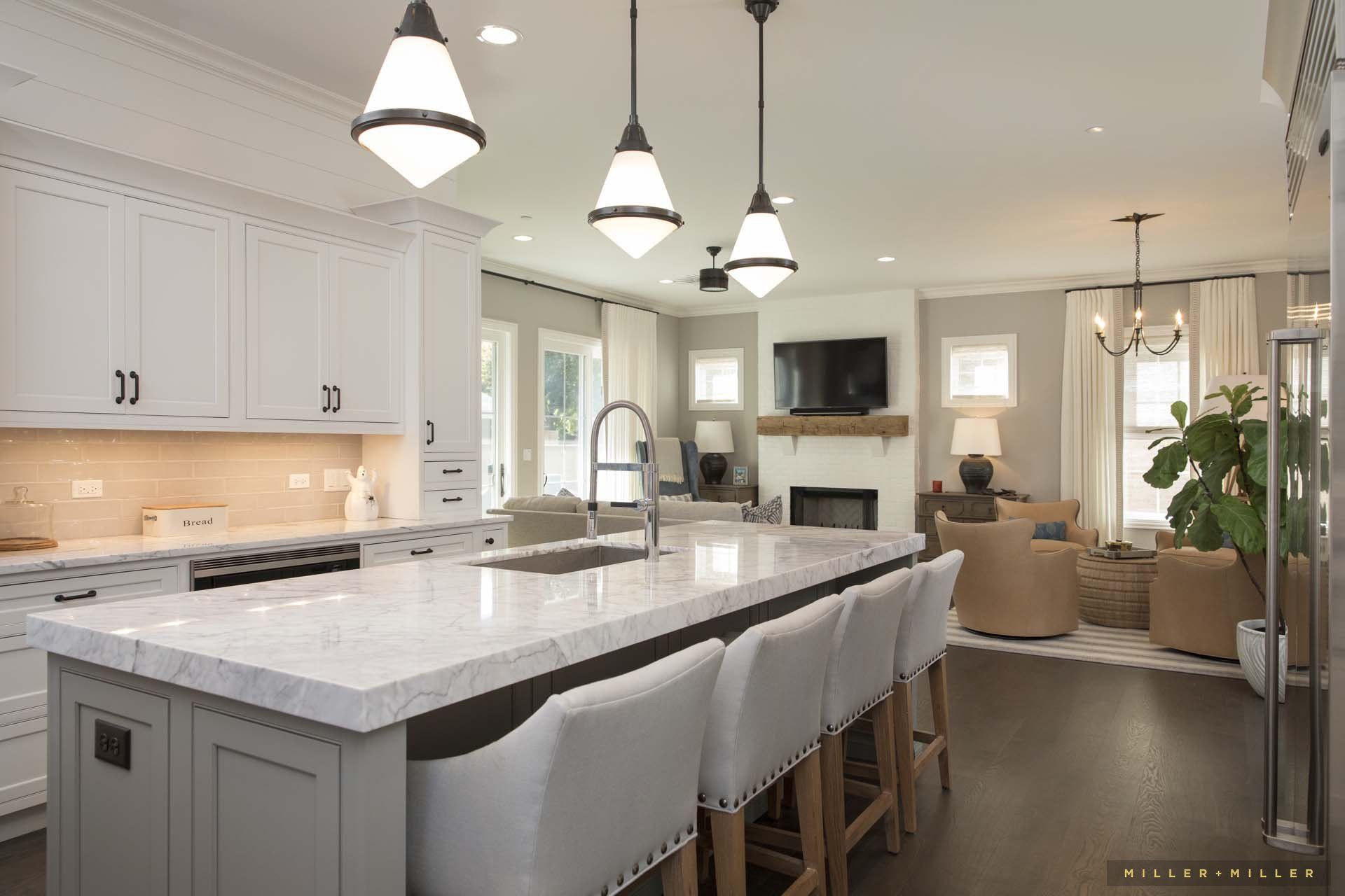 A kitchen with a large island and white cabinets
