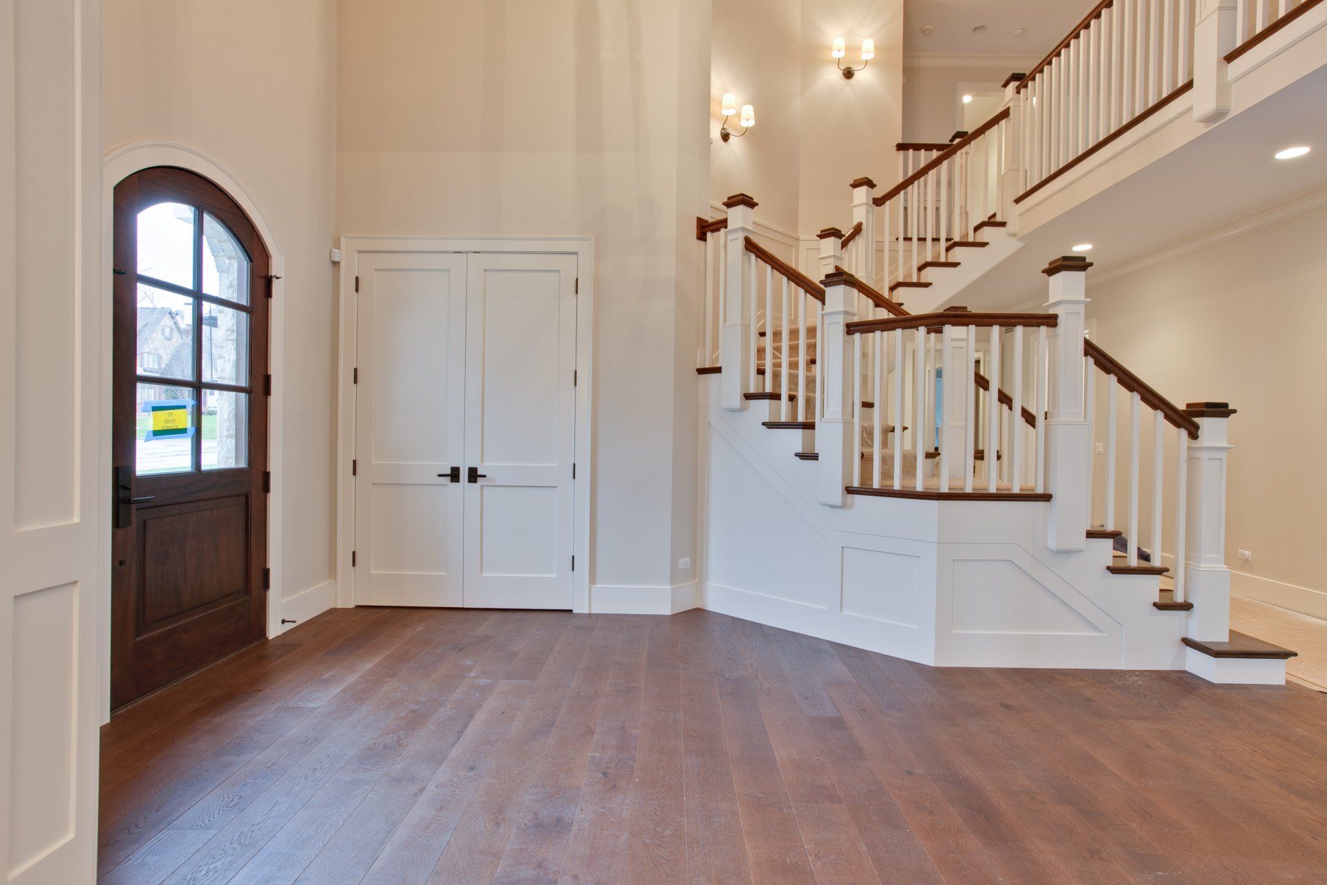 A large empty room with stairs leading up to the second floor.