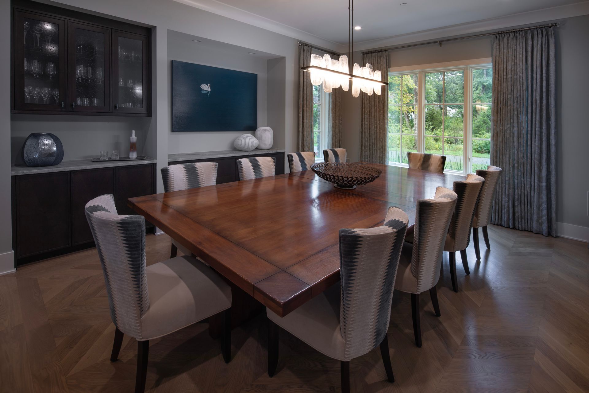 A dining room with a large wooden table and chairs