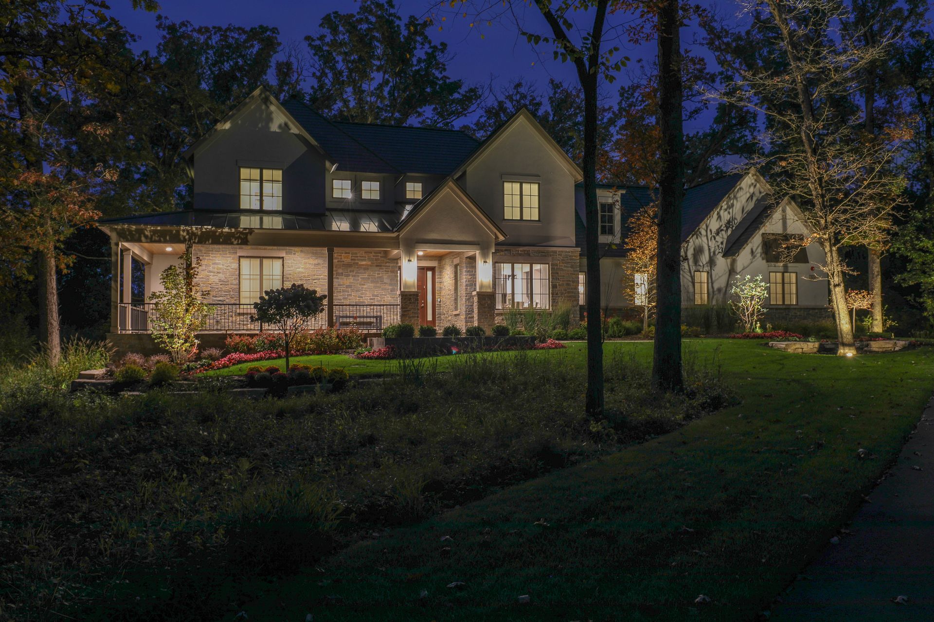 A large house with a lot of windows is lit up at night