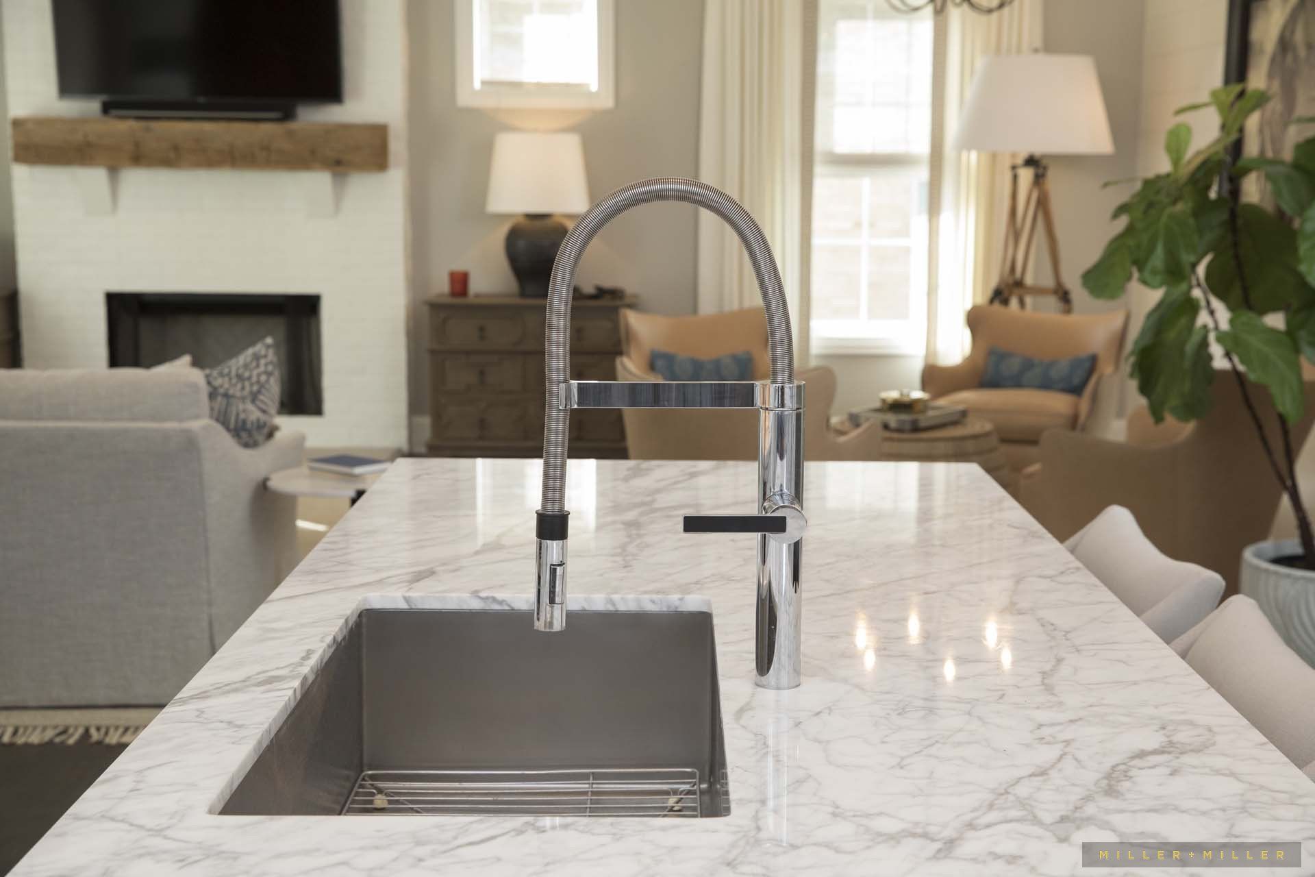 A kitchen sink is sitting on top of a marble counter in a living room.