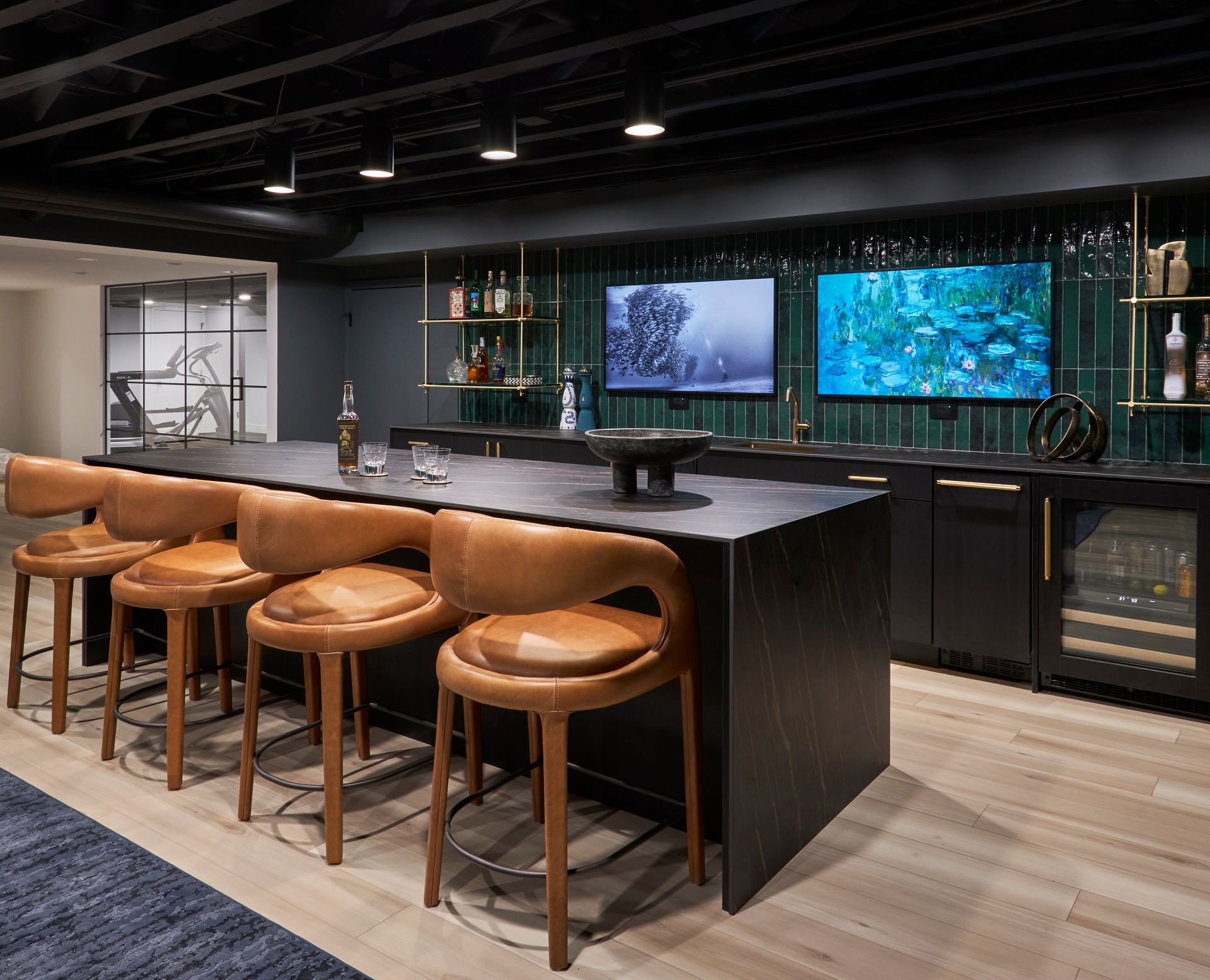 A bar with stools and a television on the wall.