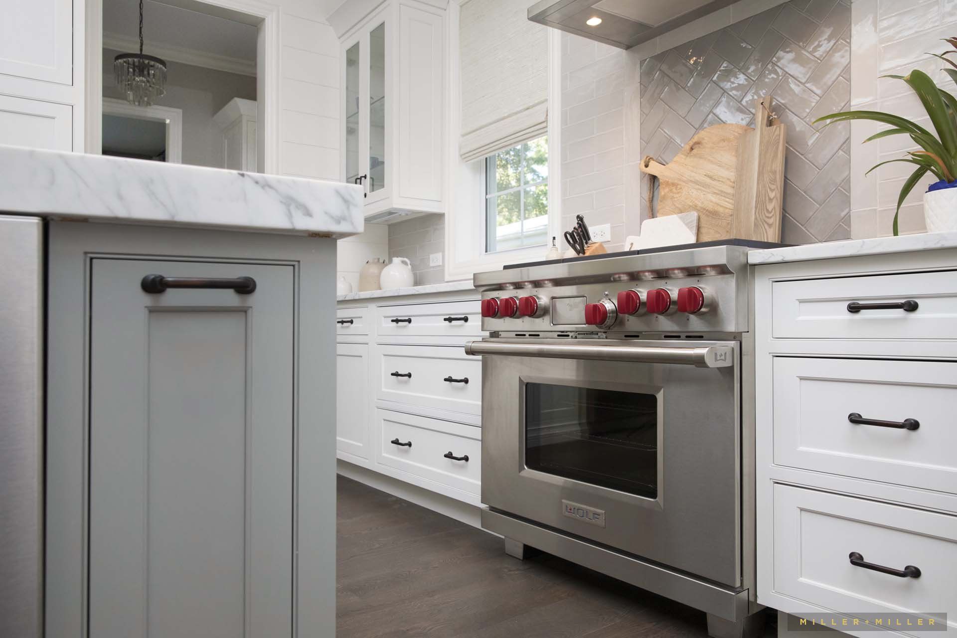 A kitchen with stainless steel appliances and white cabinets.