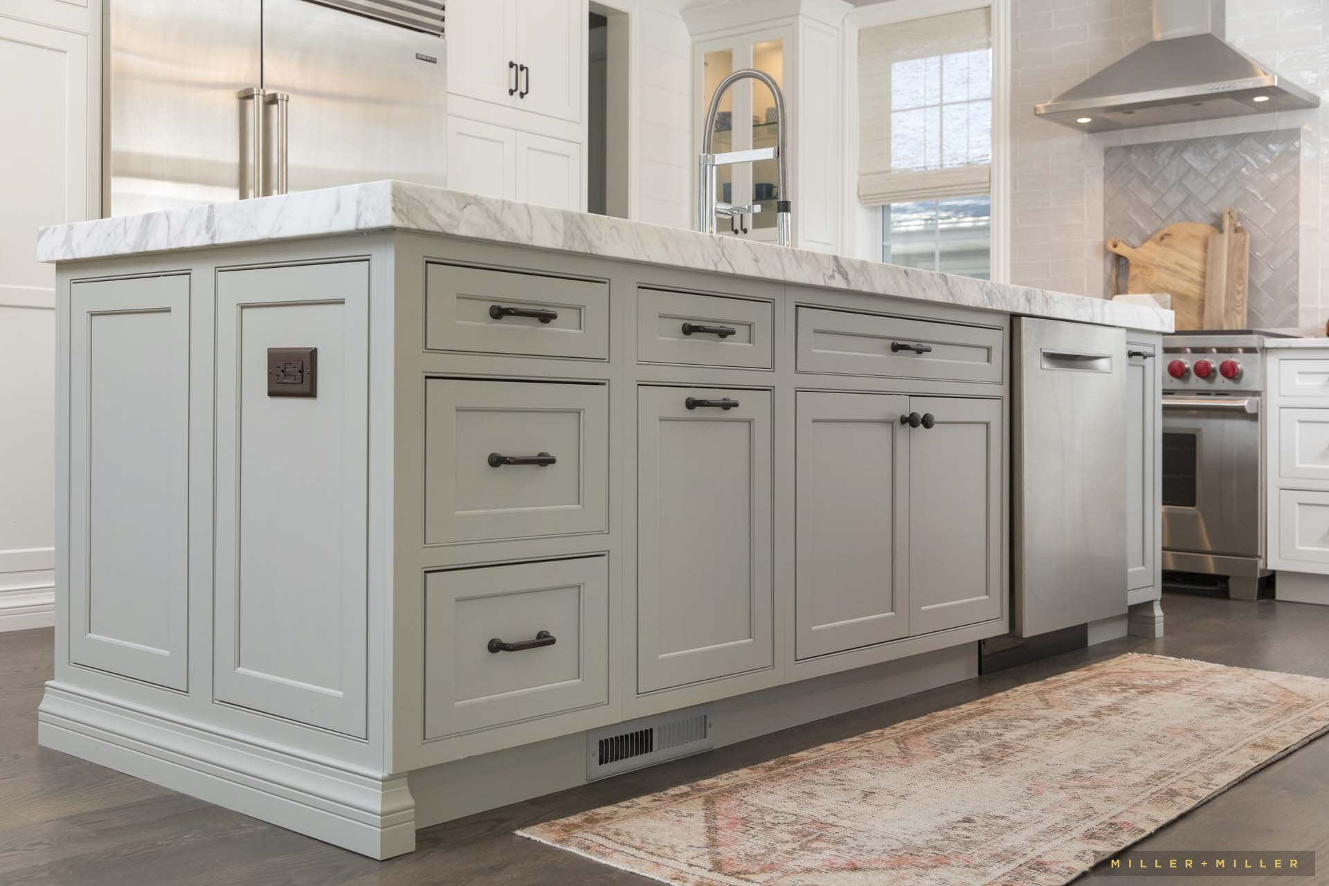 A kitchen with a large island and a rug on the floor.