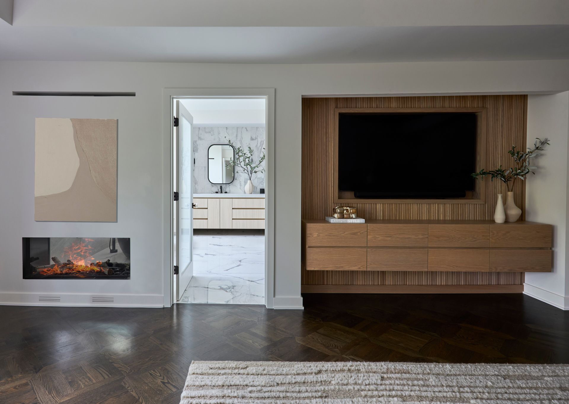 A living room with a fireplace and a flat screen tv on the wall.