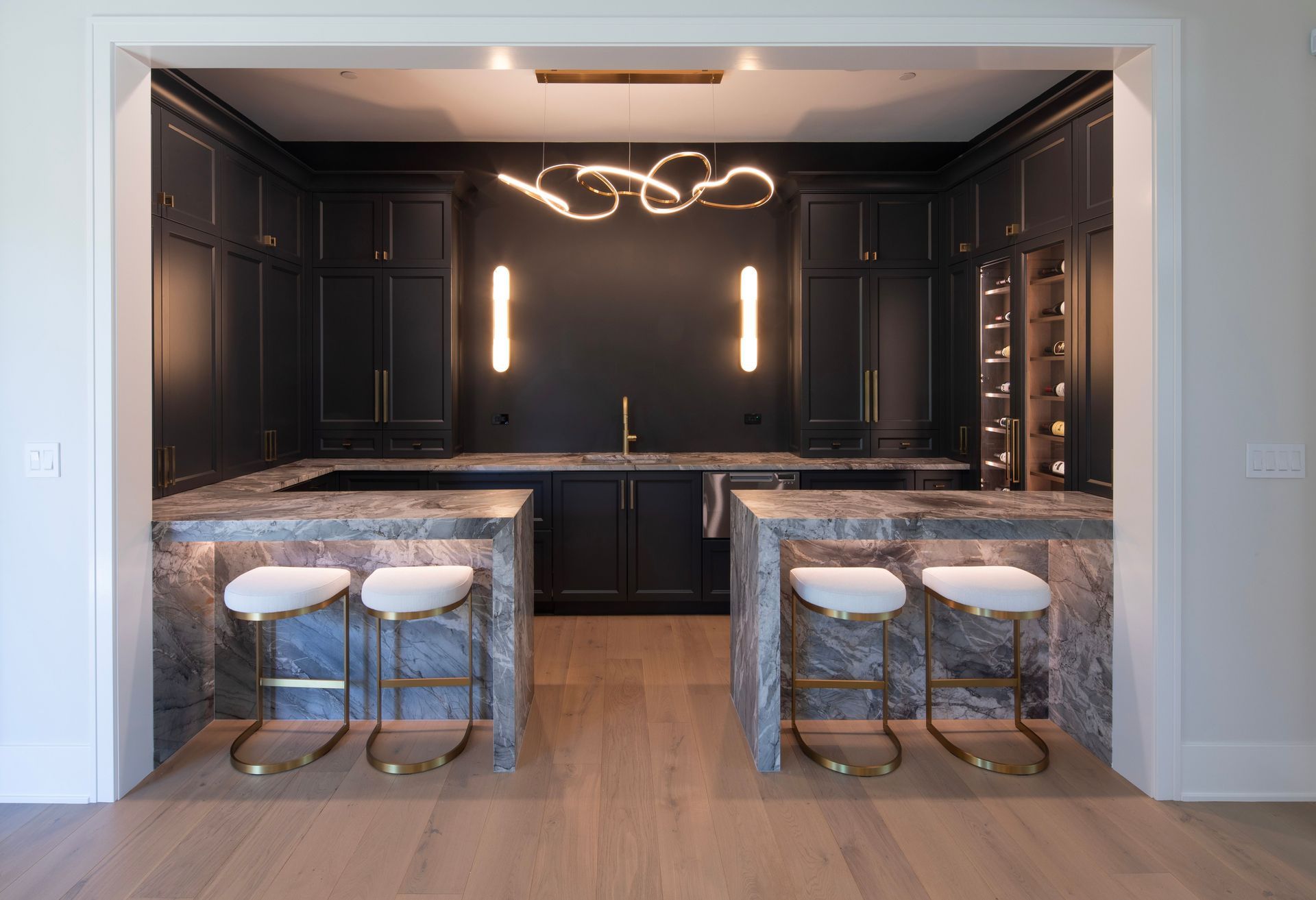 A kitchen with a bar and stools in it.