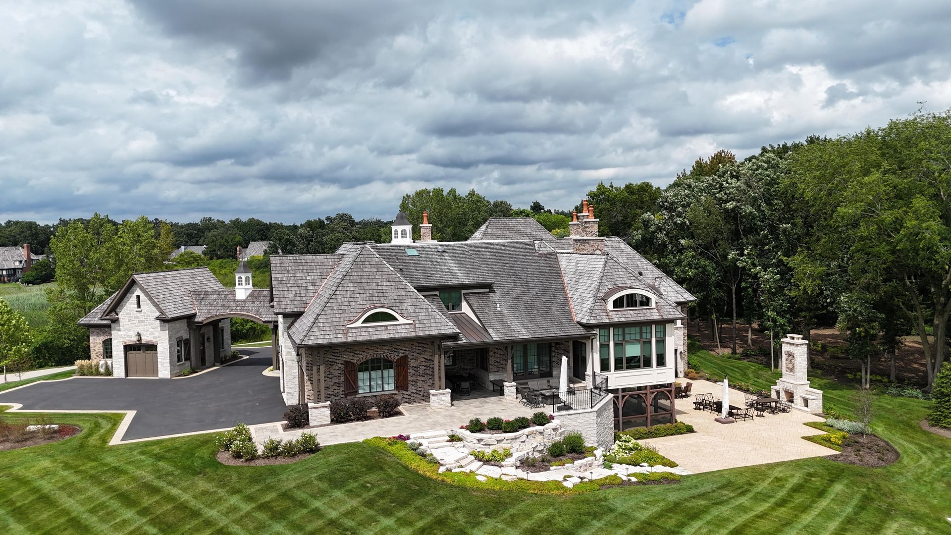 An aerial view of a large house with a large lawn in front of it.