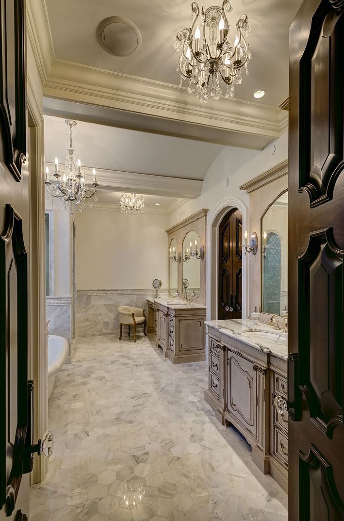 A bathroom with two sinks and a chandelier hanging from the ceiling.