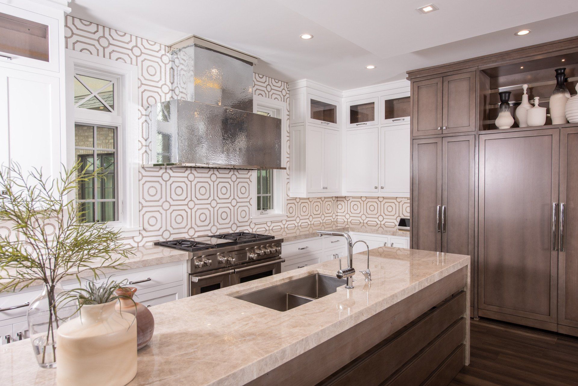 A kitchen with a stove , sink , refrigerator and cabinets.