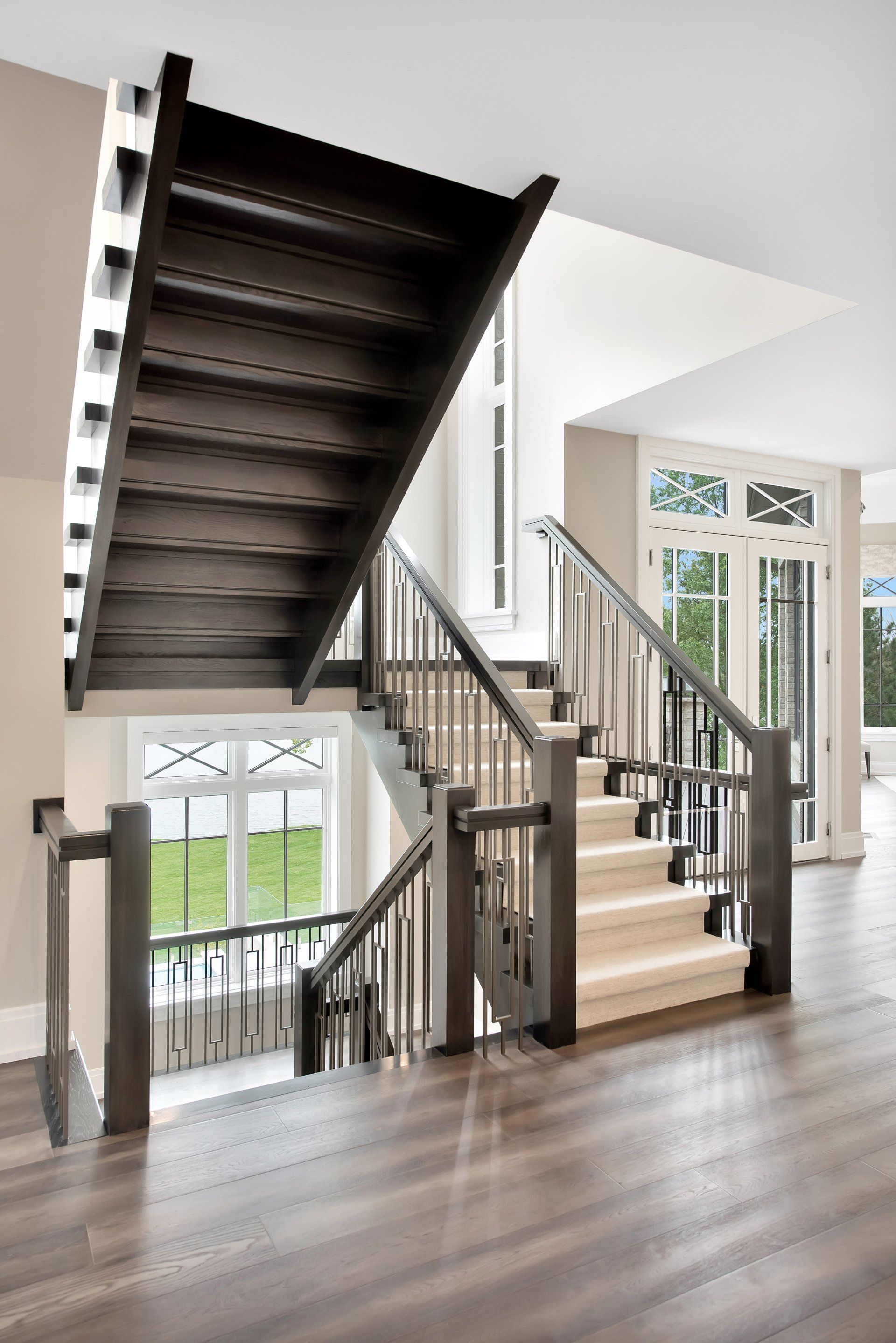 A wooden staircase with a white carpet in a house.