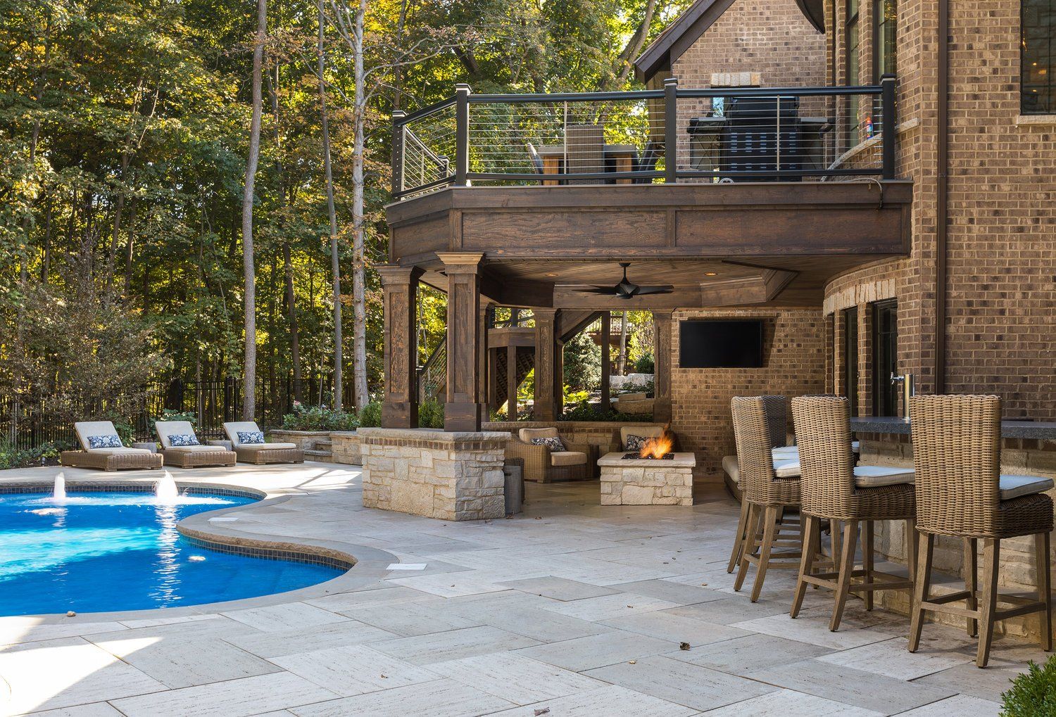 There is a large swimming pool in the backyard of a house.