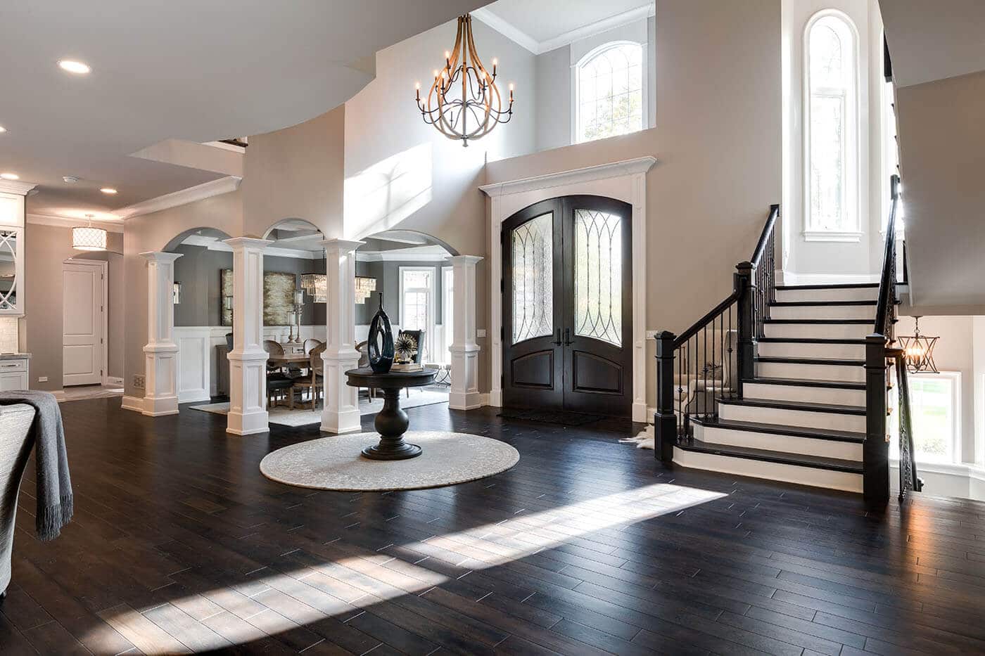 A large living room with hardwood floors and stairs leading up to the second floor.