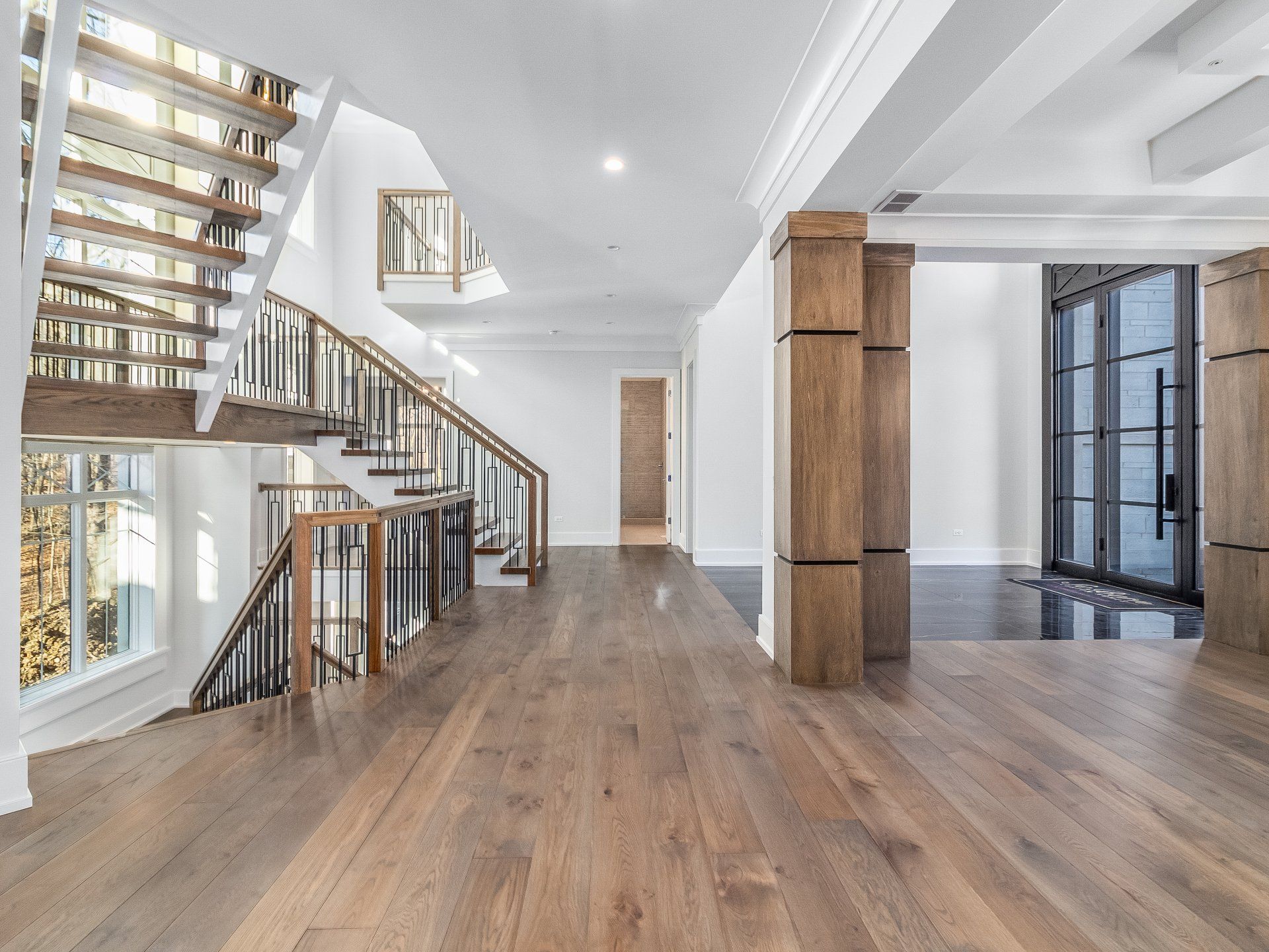 A large empty room with hardwood floors and stairs.