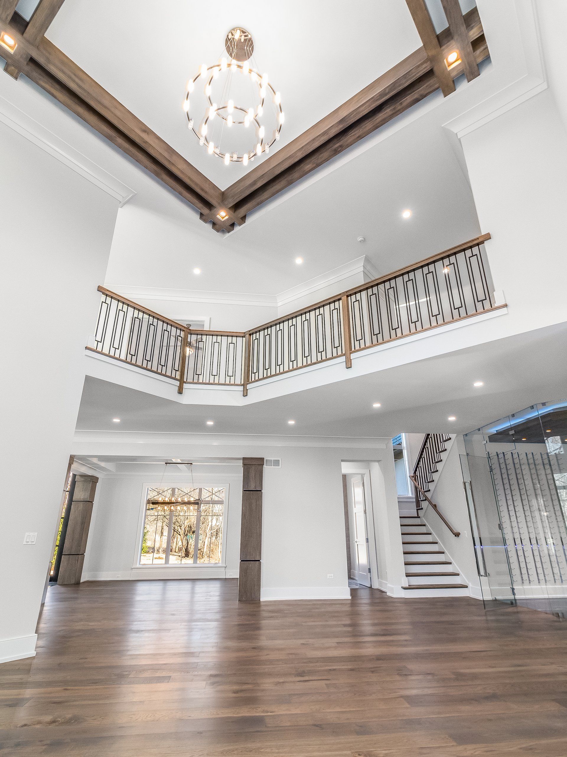 A large empty room with a balcony and stairs.