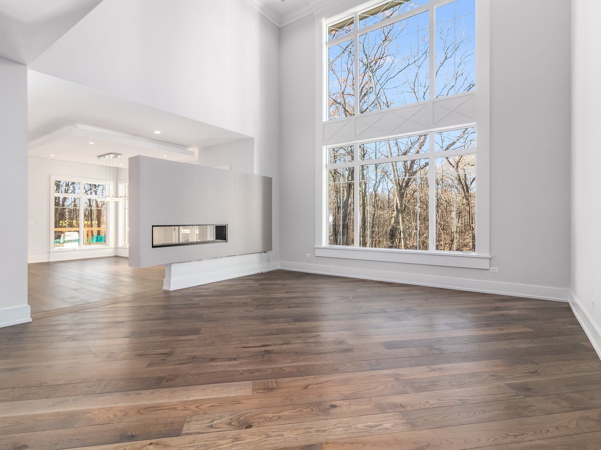 An empty living room with hardwood floors and a fireplace.