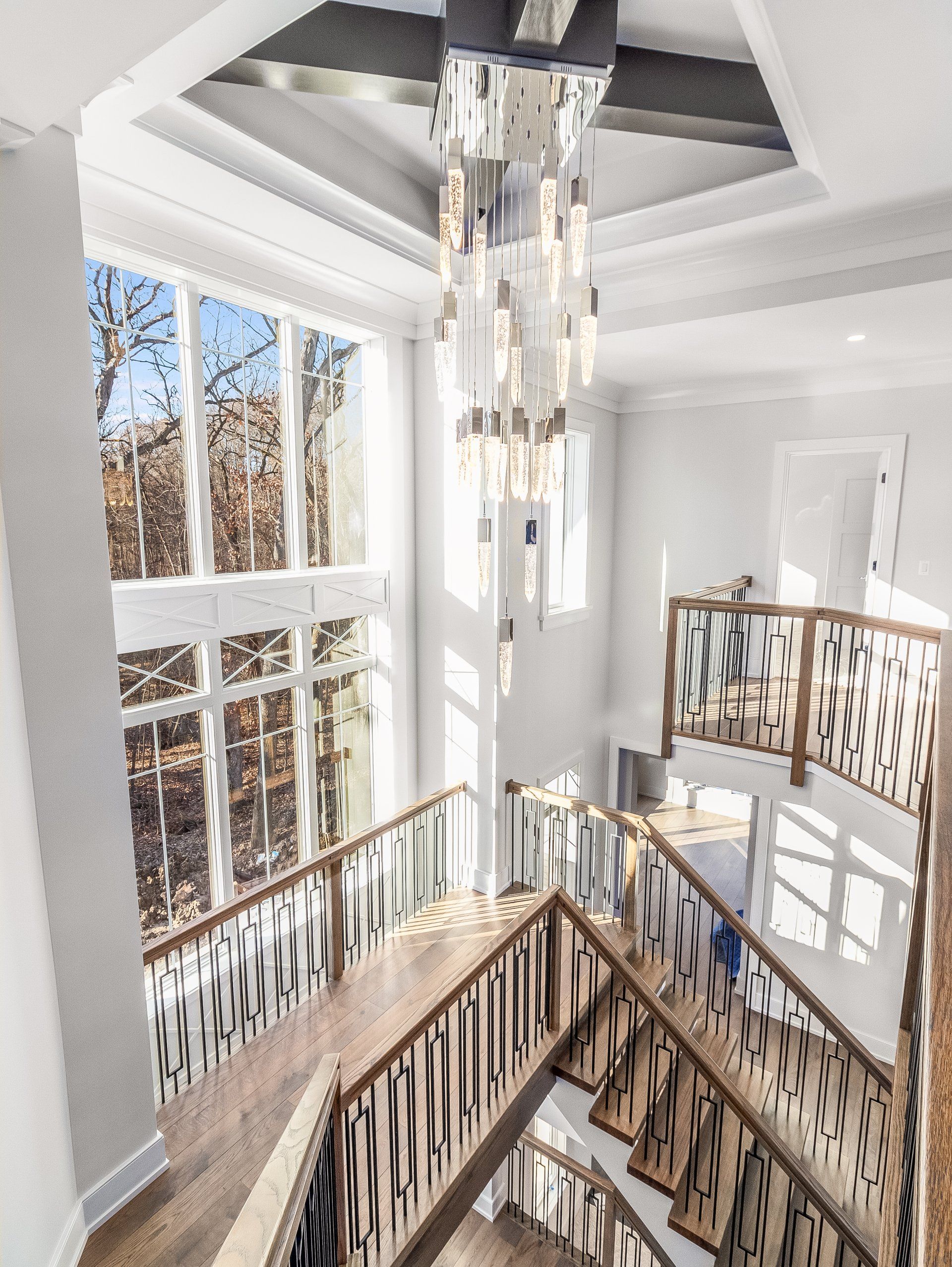 A staircase in a house with a chandelier hanging from the ceiling.