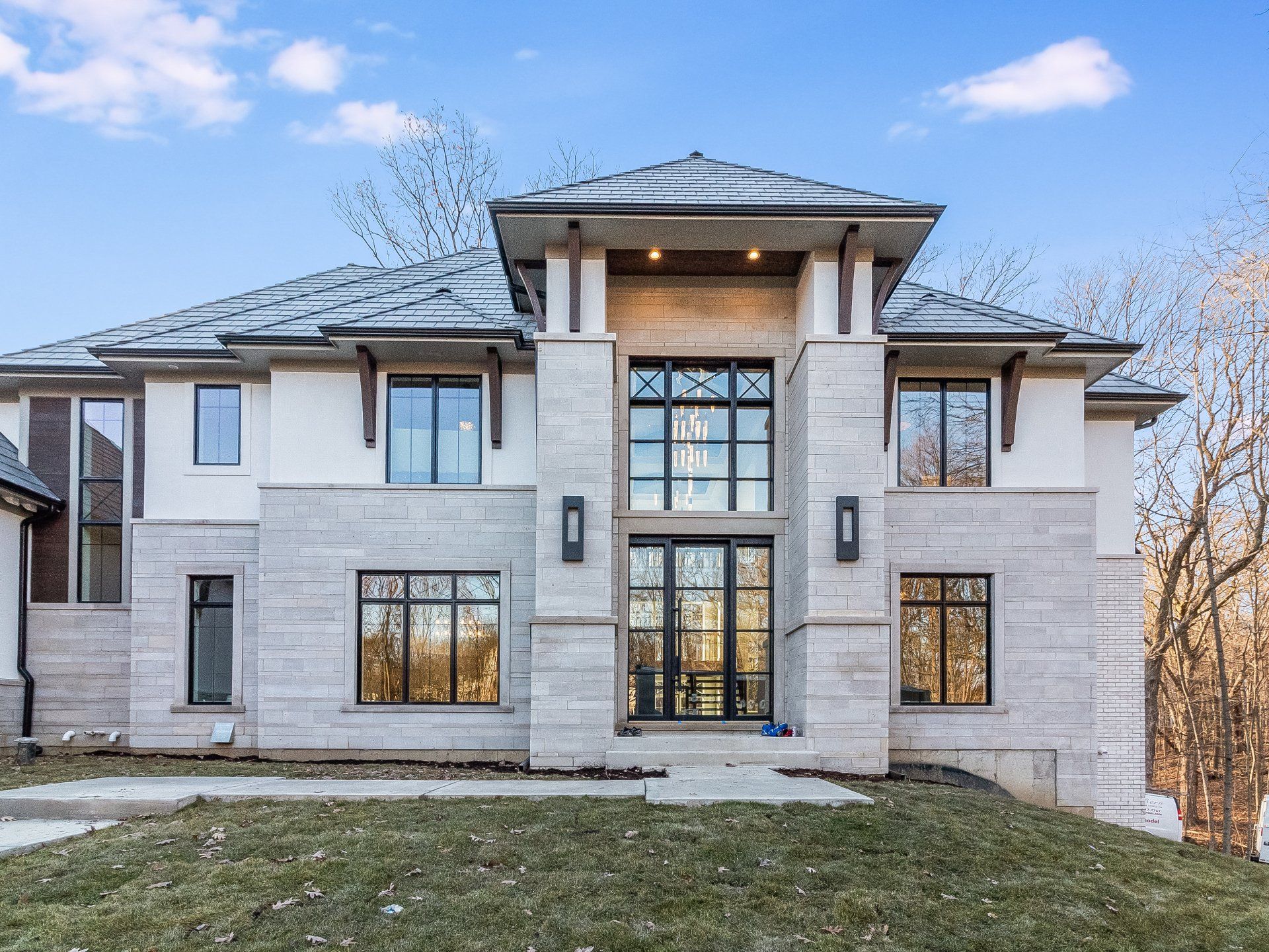 The front of a large house with a lot of windows and a roof.