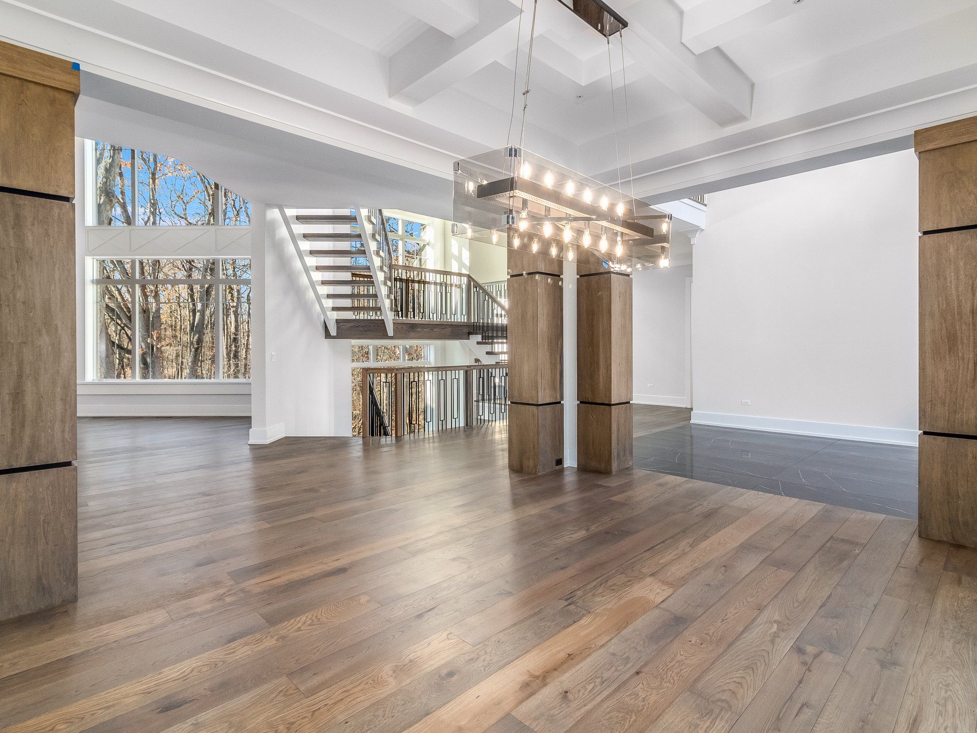 A large empty room with hardwood floors and a staircase.