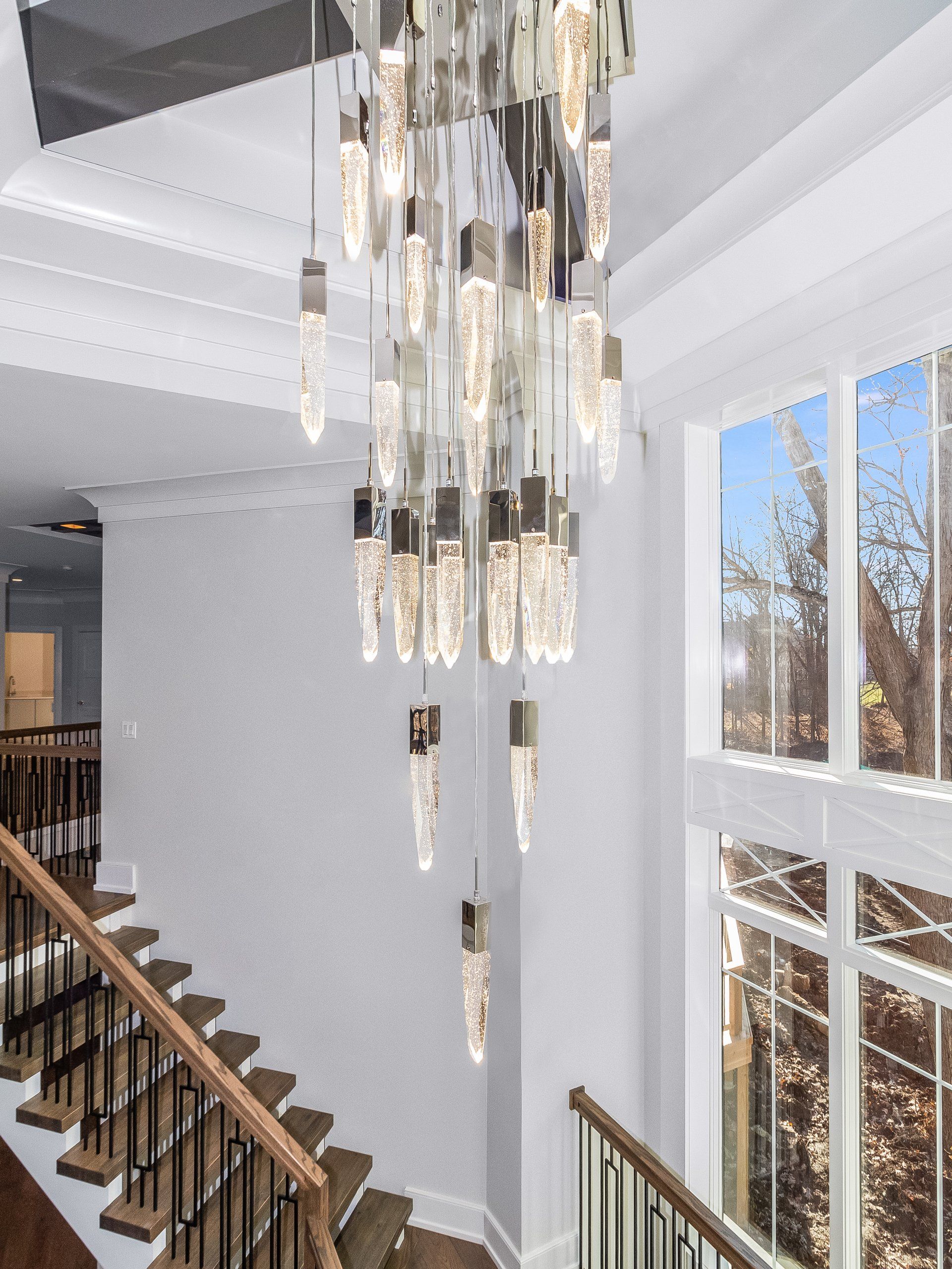 A staircase with a chandelier hanging from the ceiling